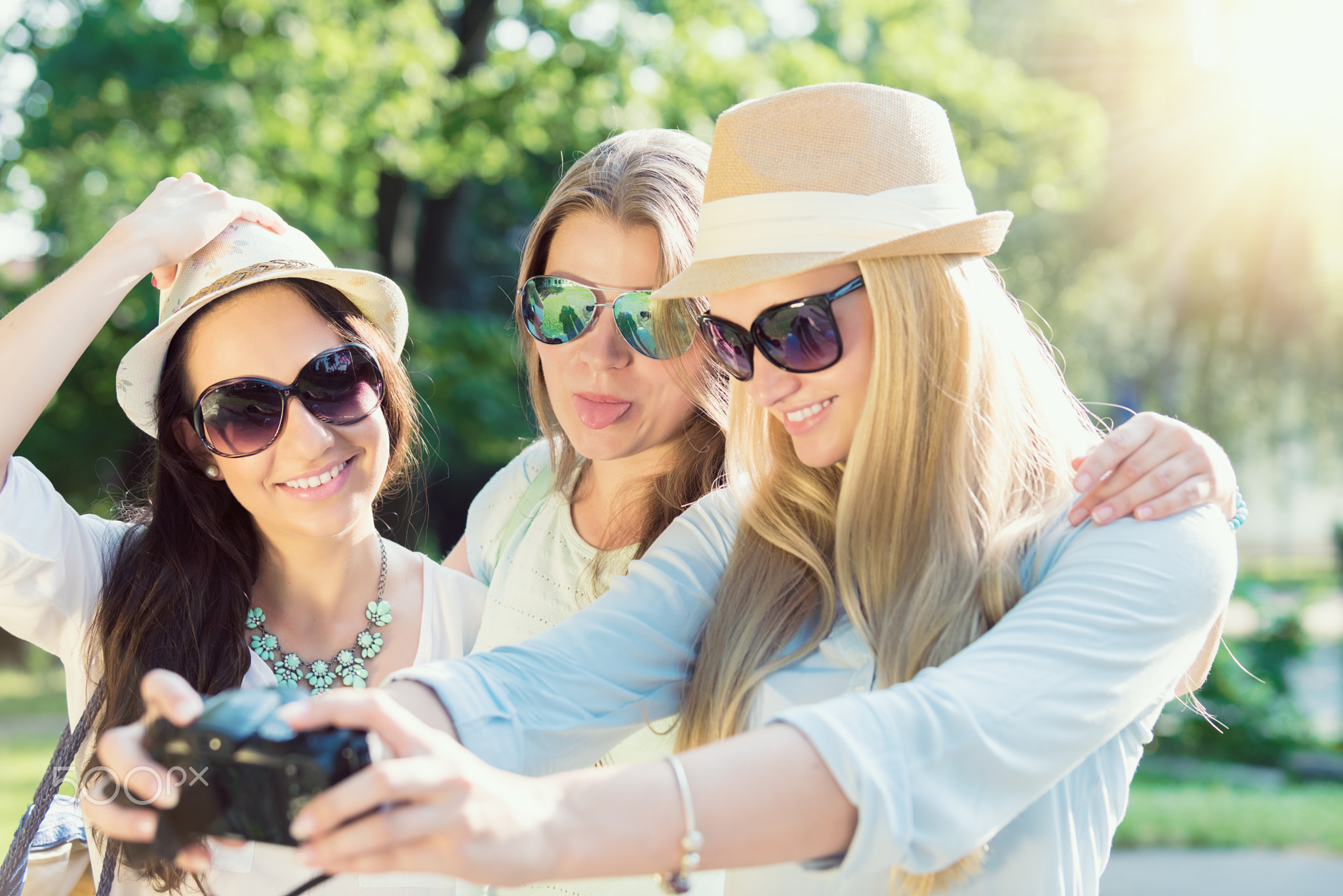 Selfie. Three attractive girls taking picture at summer holidays, girls with camera taking...