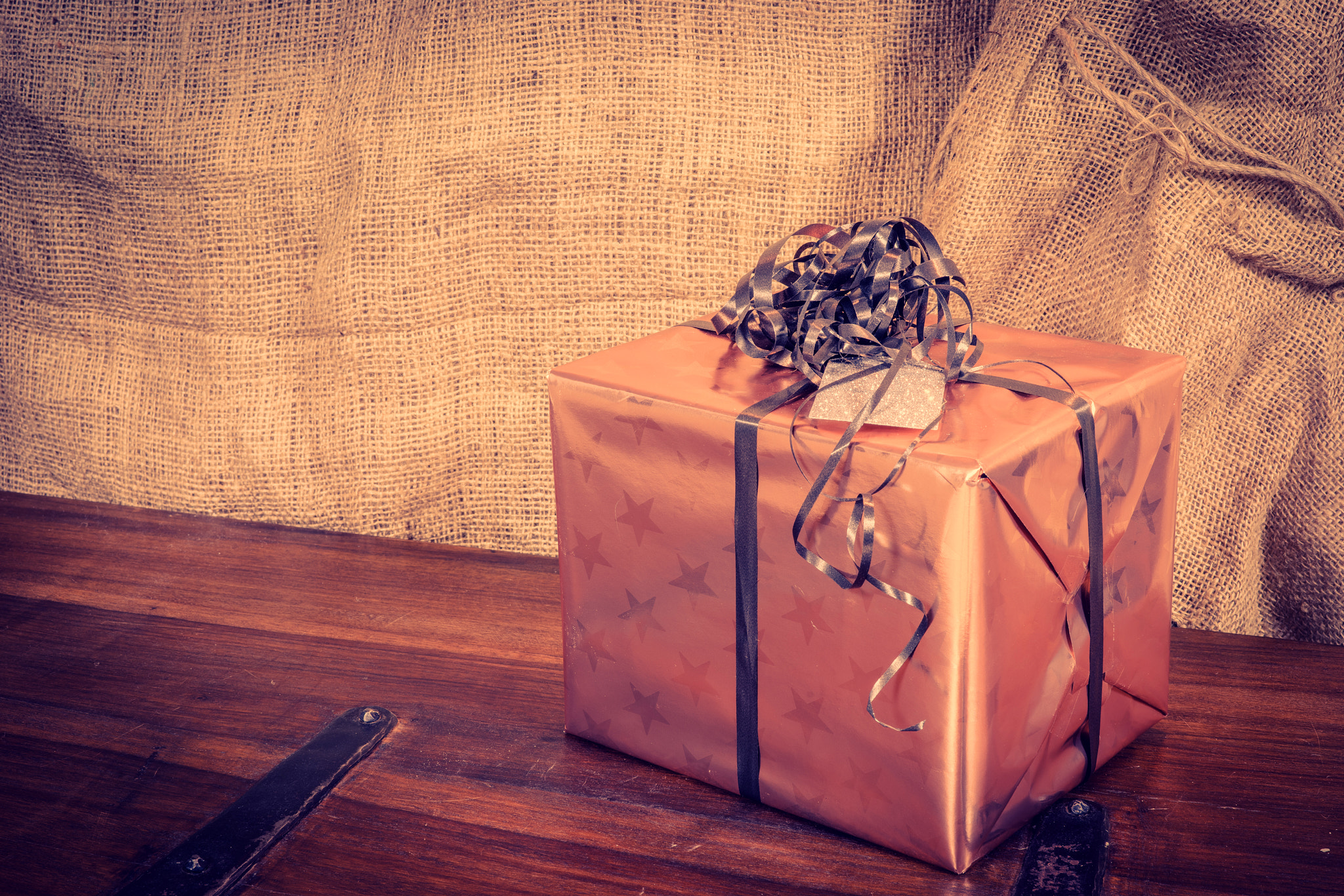 Sony a7R + Sony 50mm F1.4 sample photo. Shiny christmas present on a wooden desk photography