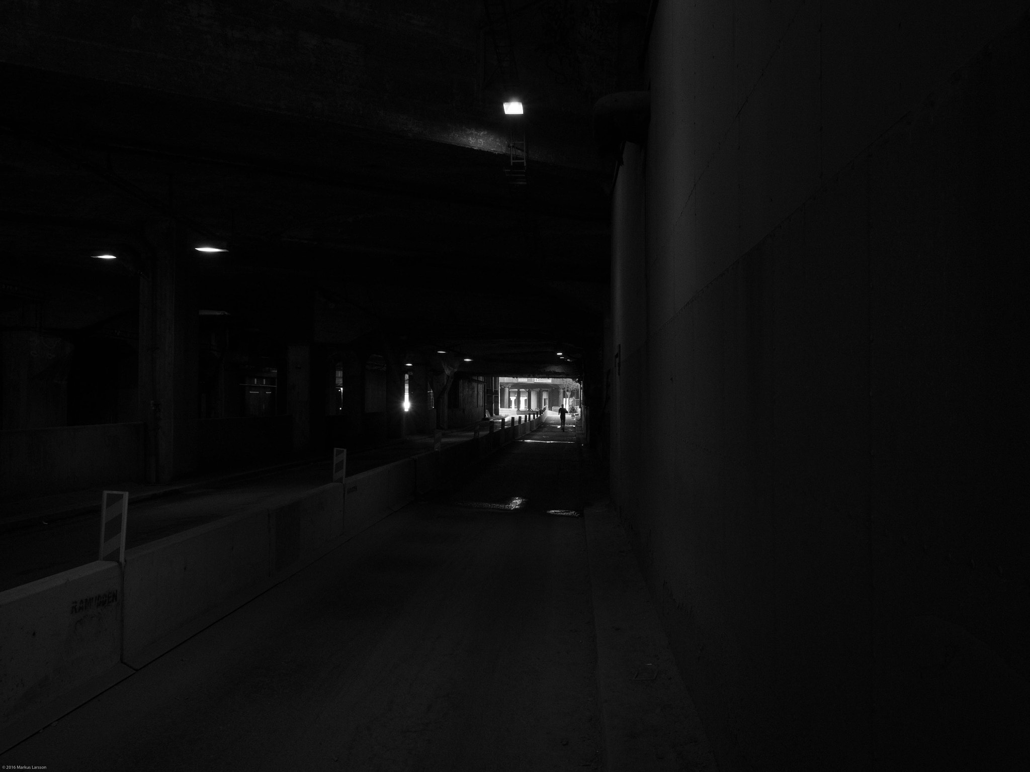 Olympus M.Zuiko Digital 17mm F1.8 sample photo. Man running out from tunnel photography