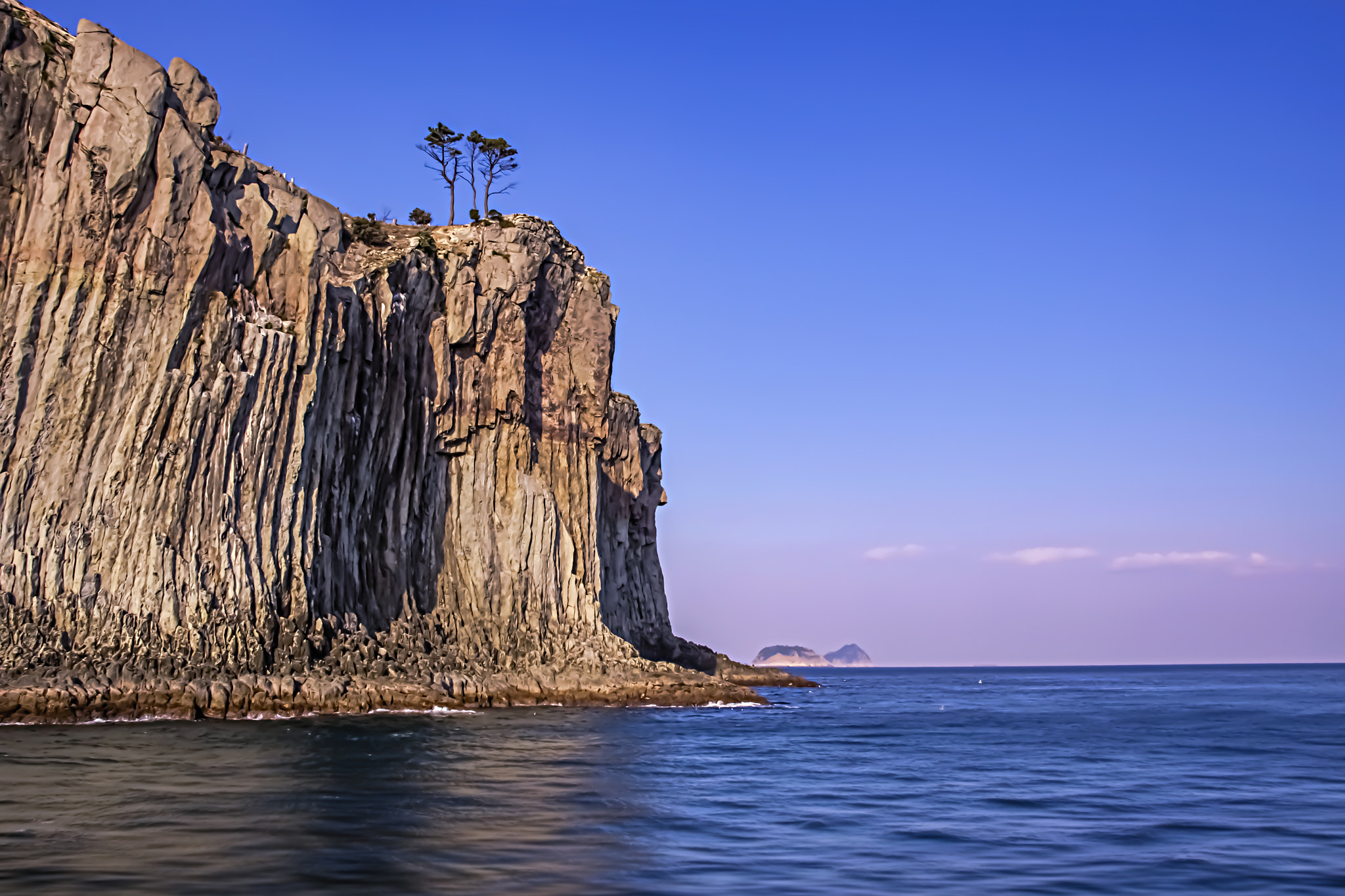Canon EF-S 18-135mm F3.5-5.6 IS STM sample photo. Trees above the cliff by the sea photography