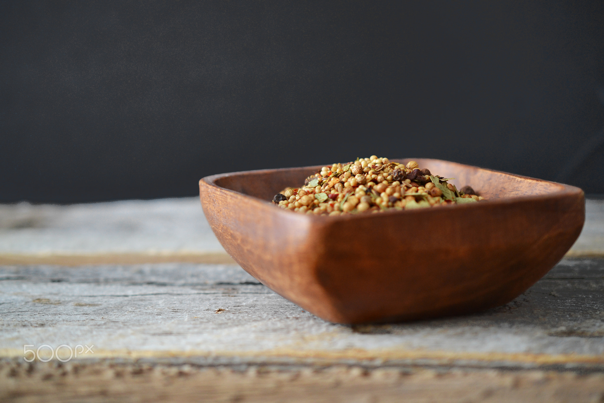 Dill spice in wood bowl on rustic dark background