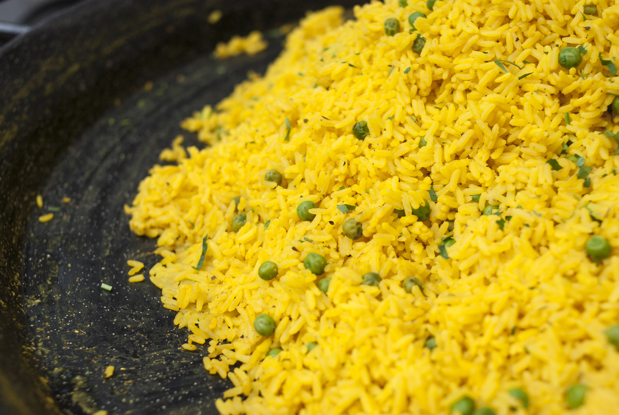 Nikon D80 + Nikon AF Nikkor 35mm F2D sample photo. Frying pan full of yellow rice with green peas photography