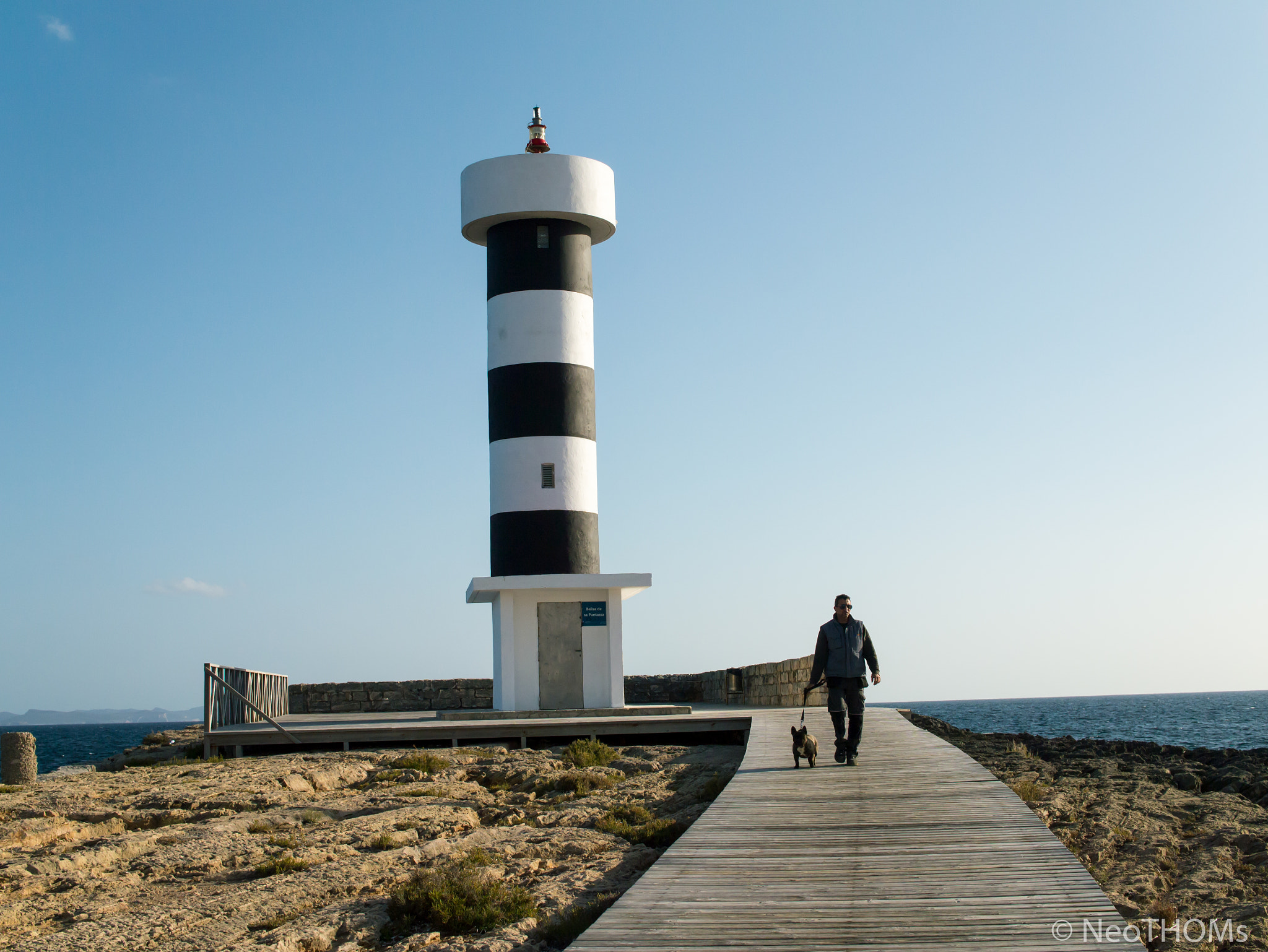 Panasonic Lumix DMC-GF6 + Olympus M.Zuiko Digital 25mm F1.8 sample photo. Lighthouse and man walking the dog photography