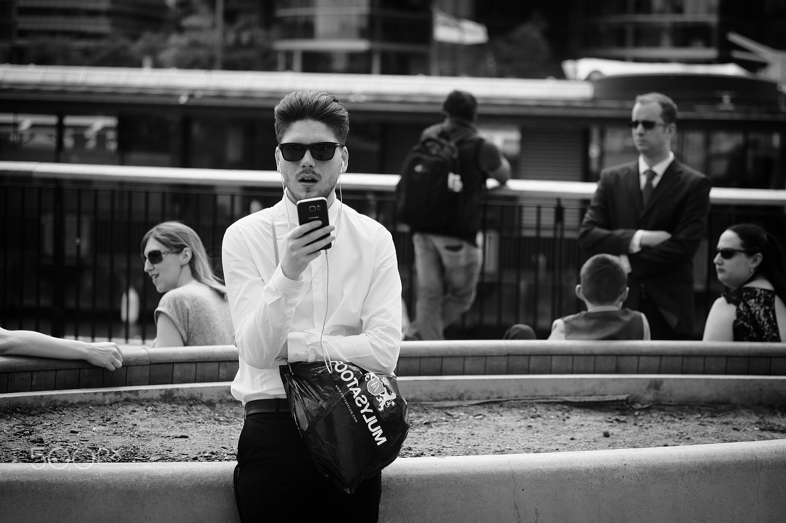 Fujifilm X-E1 + Fujifilm XF 60mm F2.4 R Macro sample photo. Guy looking at his phone photography