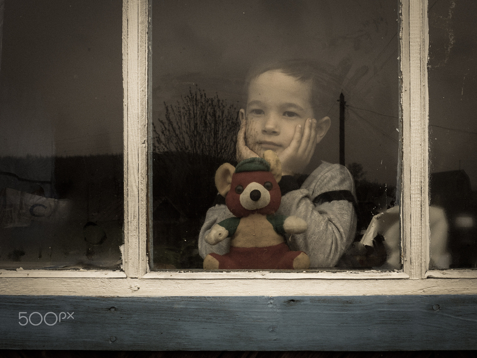 Olympus OM-D E-M10 + OLYMPUS M.12-50mm F3.5-6.3 sample photo. Young boy standing beside window with raindrop on glass photography