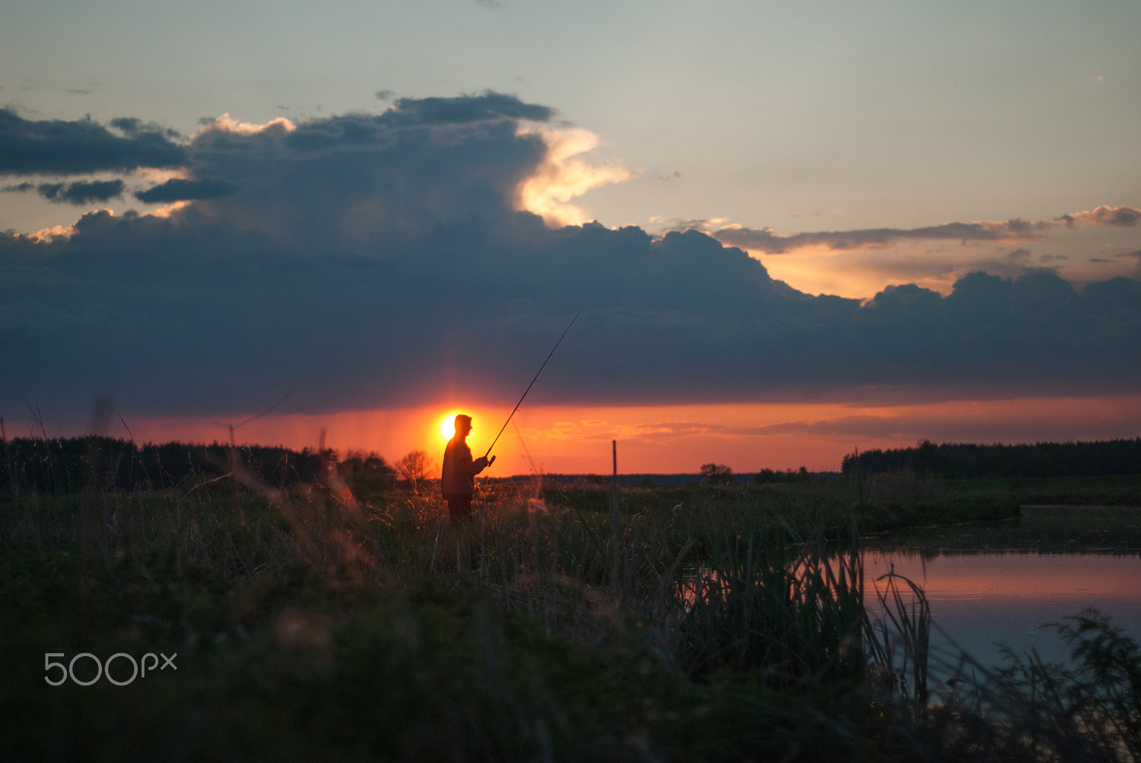 Nikon D80 + AF Nikkor 50mm f/1.8 N sample photo. Man catches a fish on spinning at sunset photography