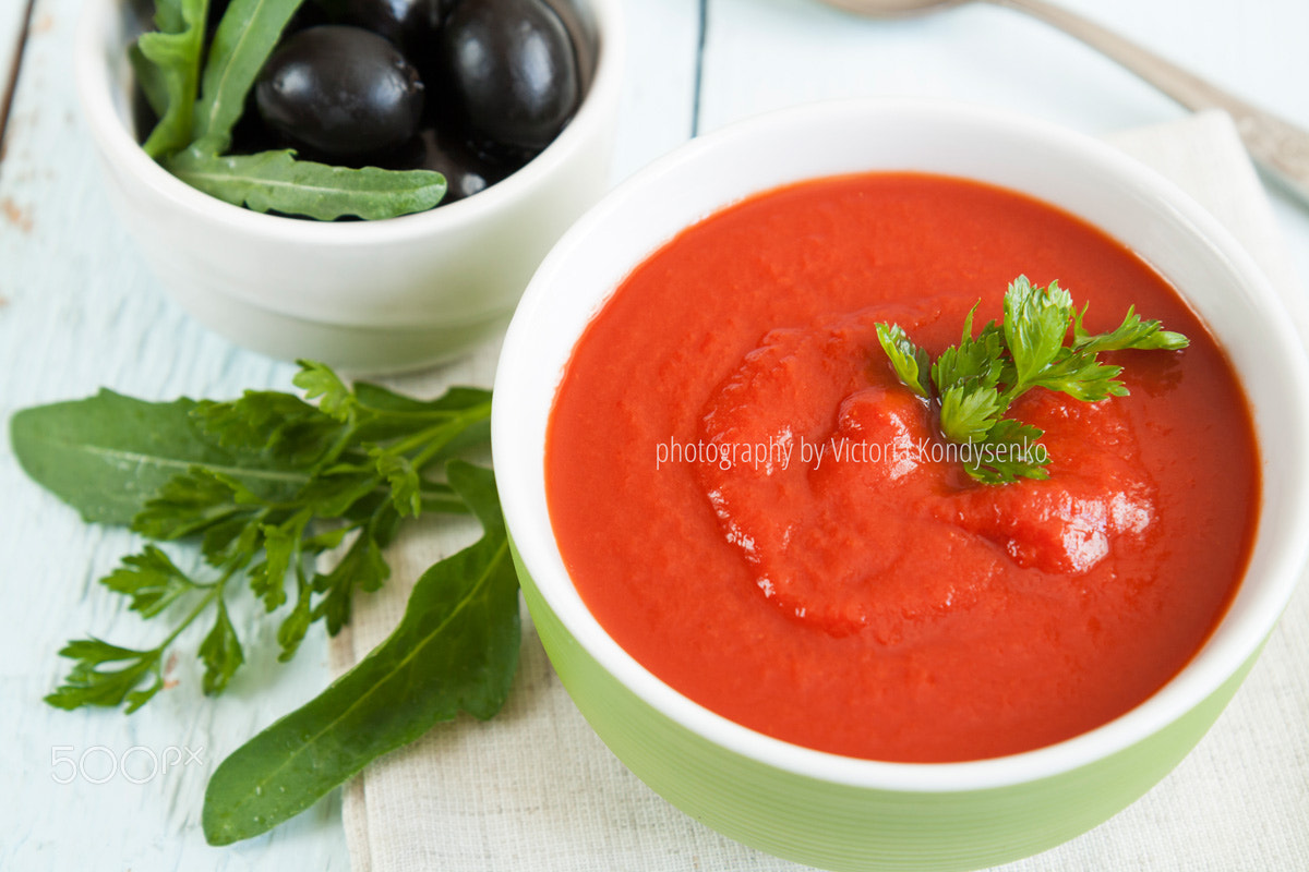 Canon EOS 1000D (EOS Digital Rebel XS / EOS Kiss F) sample photo. Colorful tomato soup on a white background, closeup photography