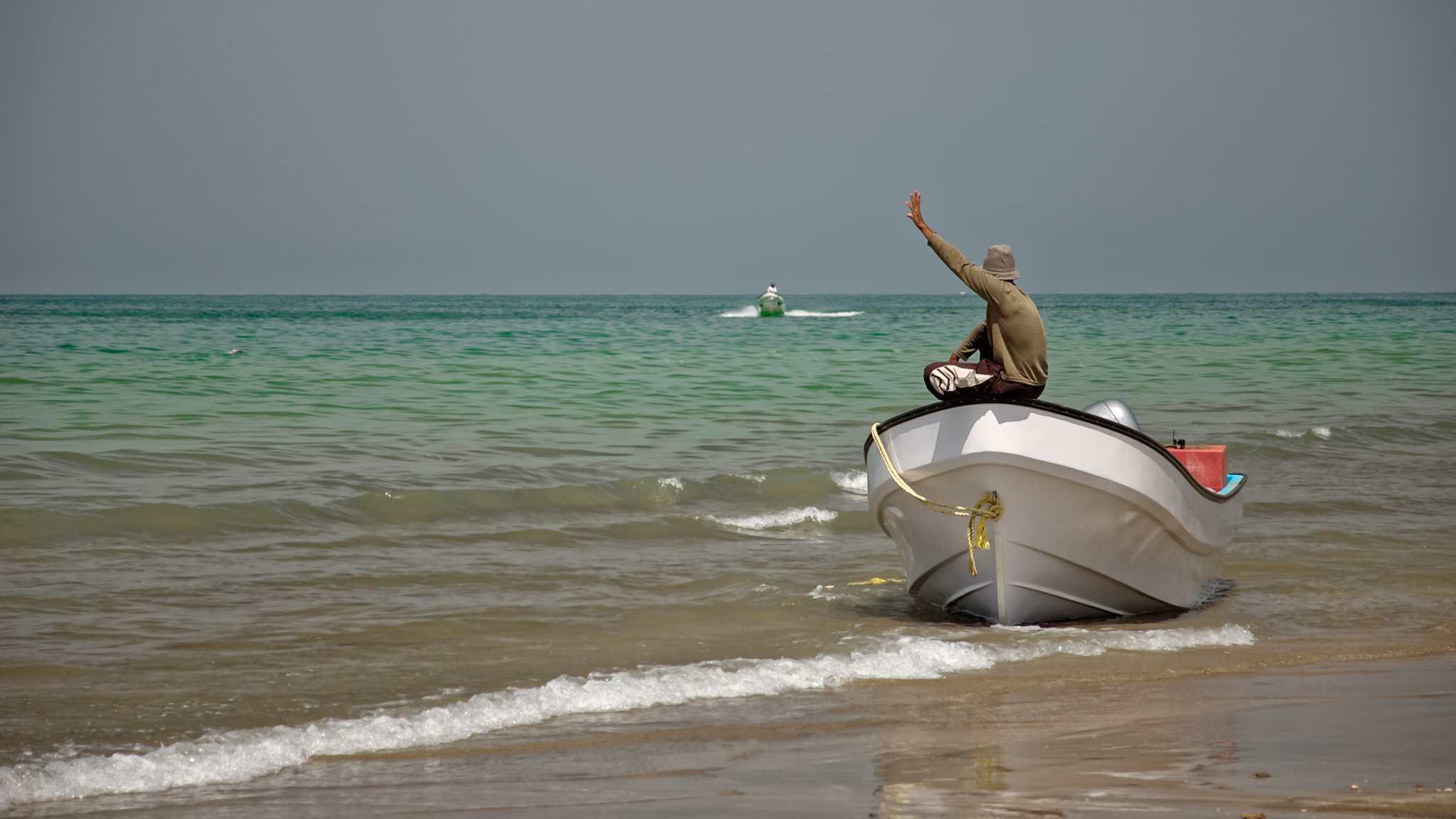 Nikon D70 sample photo. Man sitting on a boat waving photography