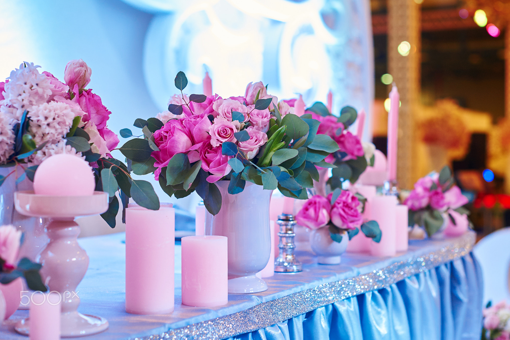 Table set for wedding reception with candles and flower bouquets