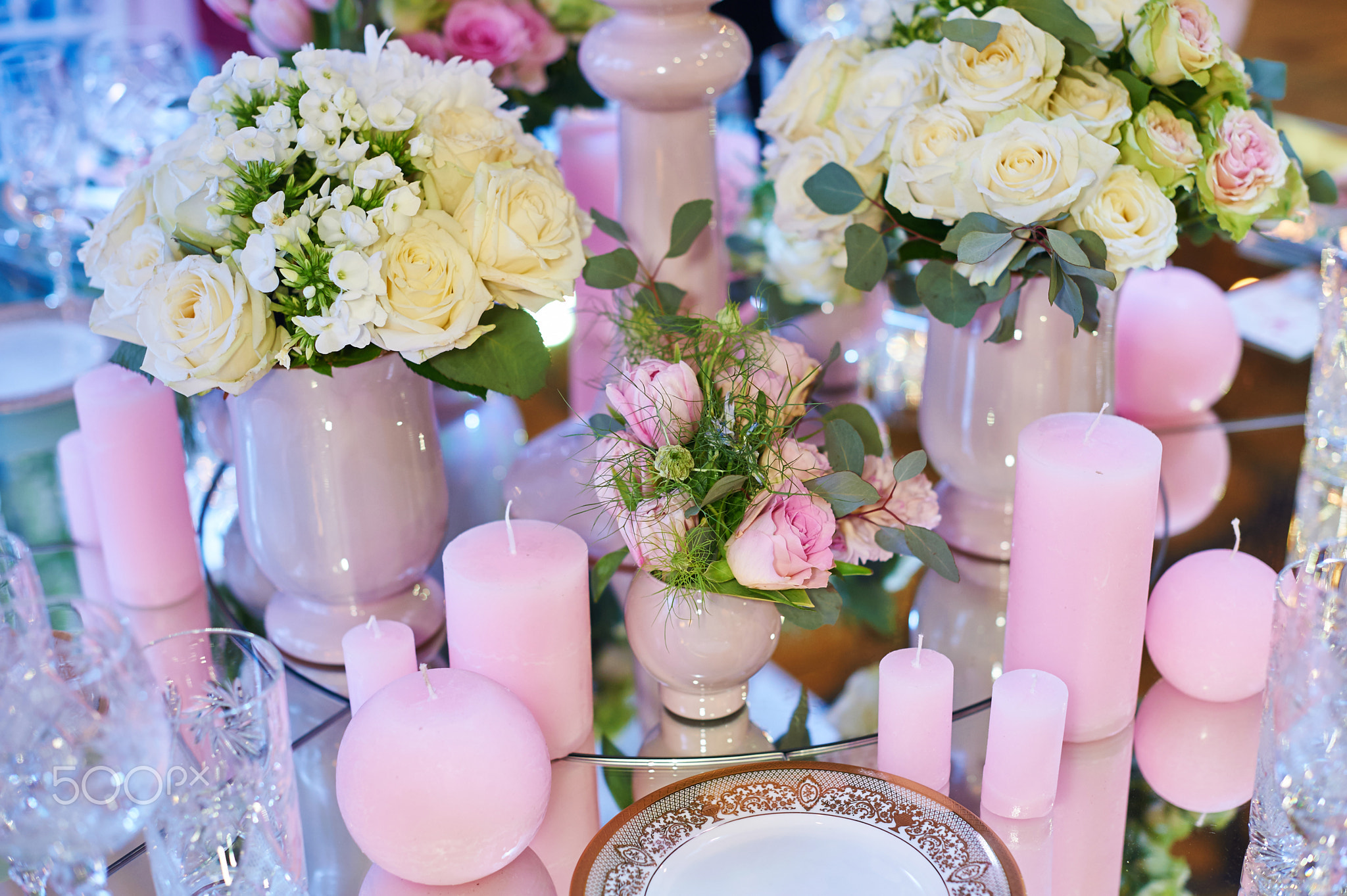 Table set for wedding reception with candles and flower bouquets