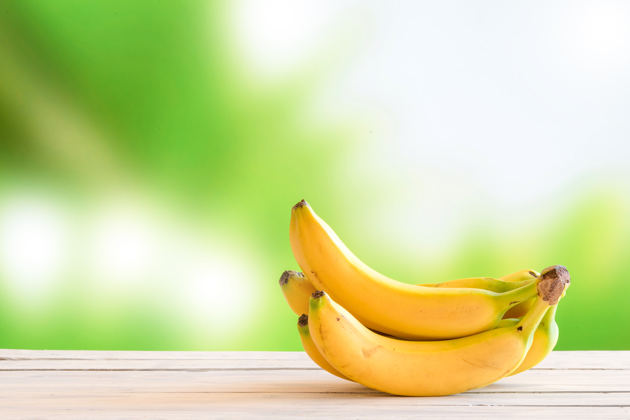 Sony a7R + Sony 70-400mm F4-5.6 G SSM II sample photo. Yellow bananas on a wooden table photography