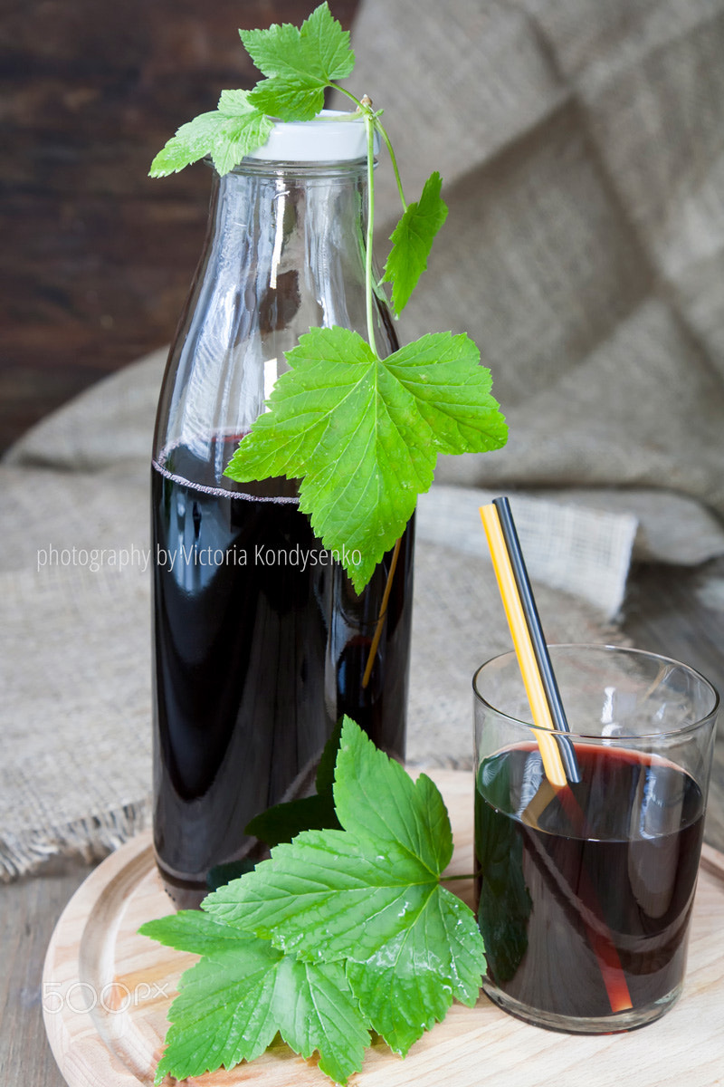 Canon EOS 1000D (EOS Digital Rebel XS / EOS Kiss F) sample photo. Glass and bottle with fresh black currant juice decoration fresh photography