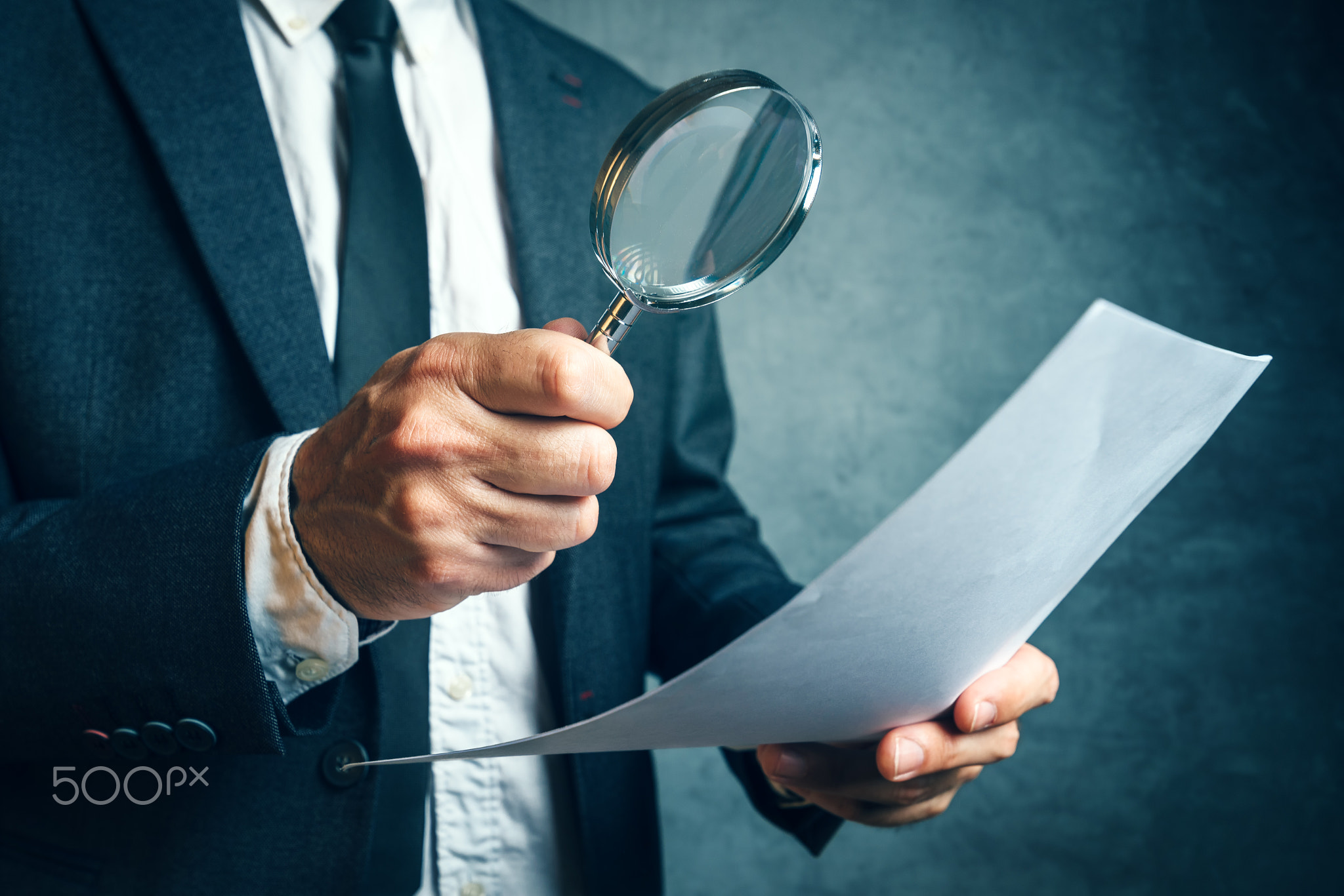 Tax inspector investigating financial documents through magnifyi
