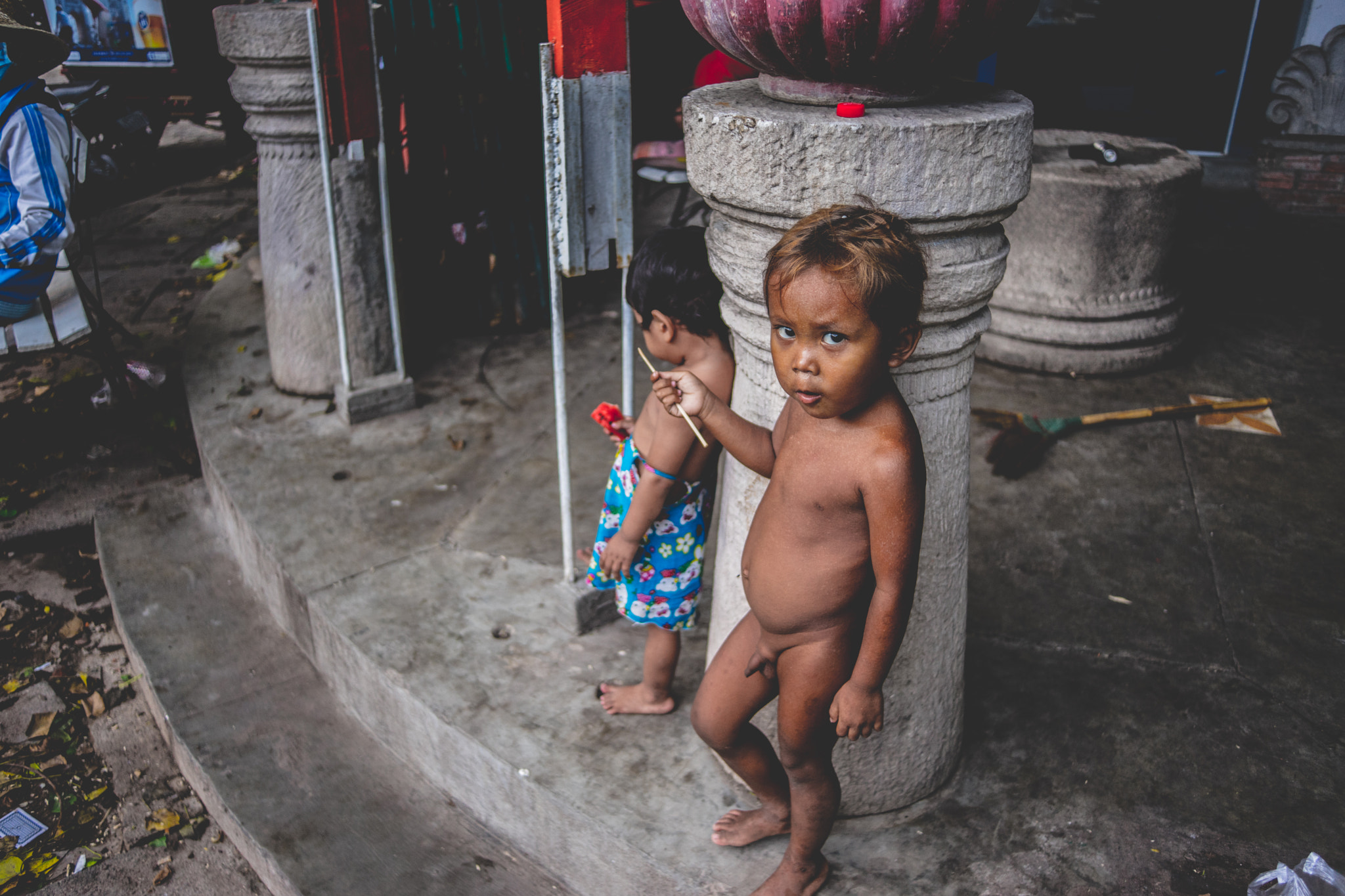 Sony a7 + Sony 28mm F2.8 sample photo. Little boy undressing on phnom penh's street photography