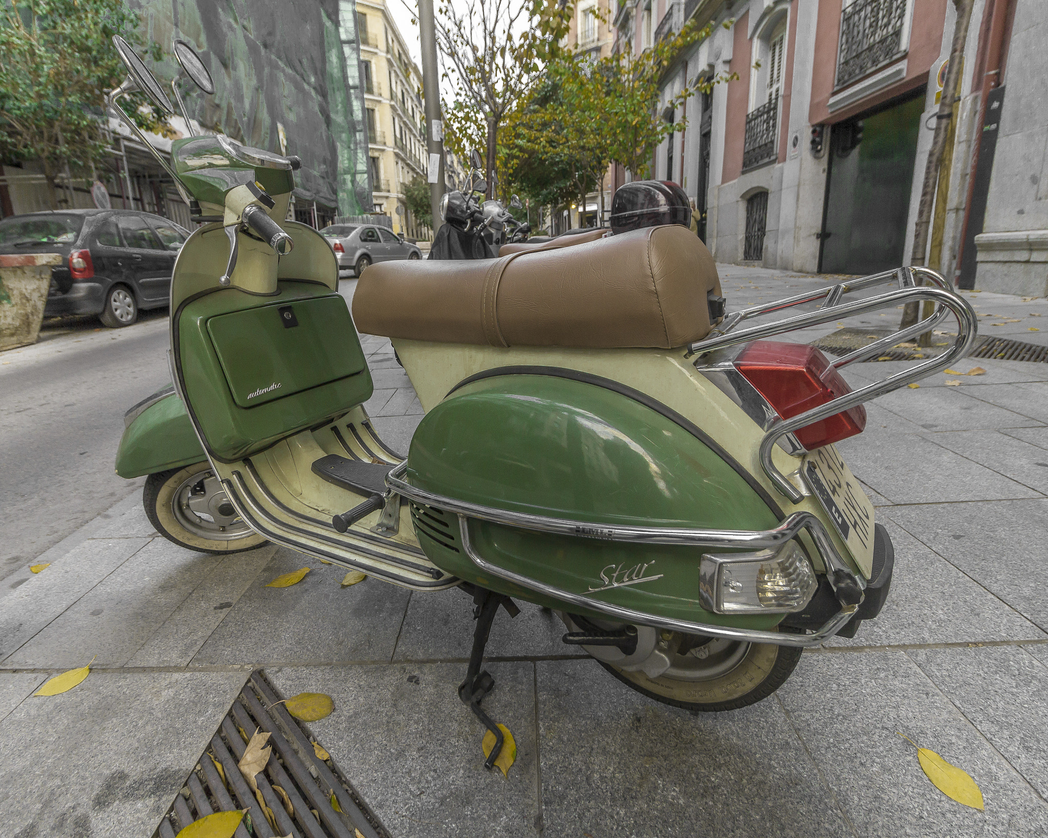 Canon EOS 550D (EOS Rebel T2i / EOS Kiss X4) + Canon EF-S 10-18mm F4.5–5.6 IS STM sample photo. Green moped on the streets of madrid photography