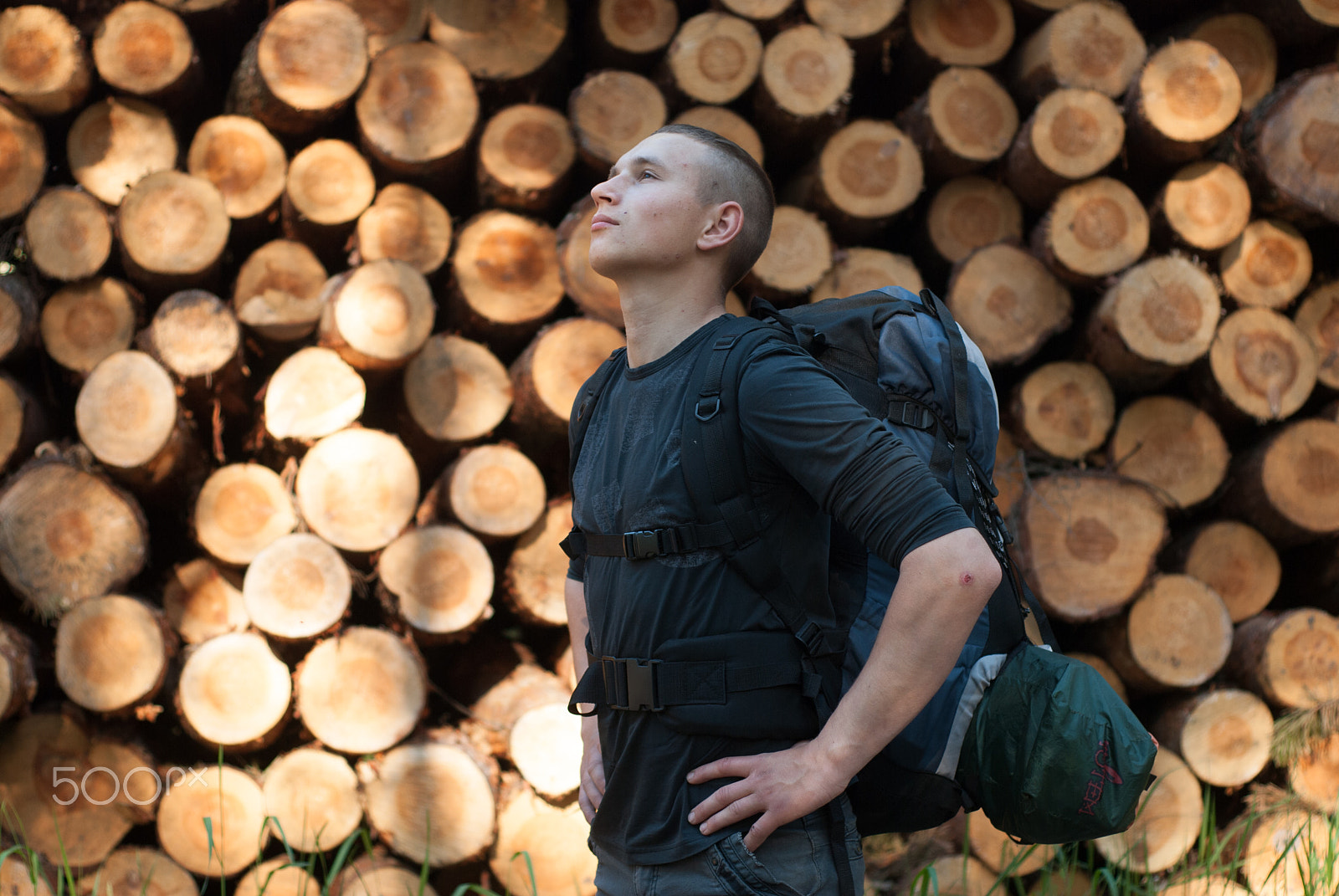 Nikon D80 + AF Nikkor 50mm f/1.8 N sample photo. Young hiker with backpack standing on a background of logs, photography