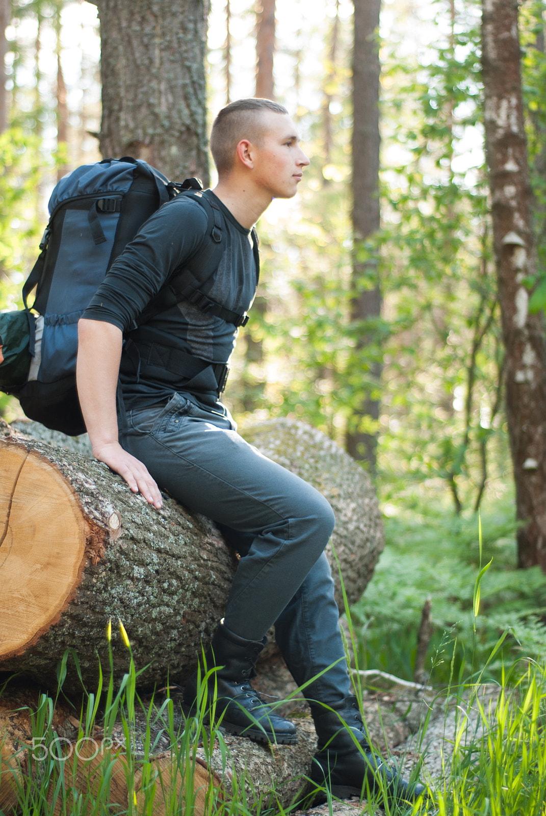 Nikon D80 + AF Nikkor 50mm f/1.8 N sample photo. A tired young hiker with backpack sitting on logs, photography
