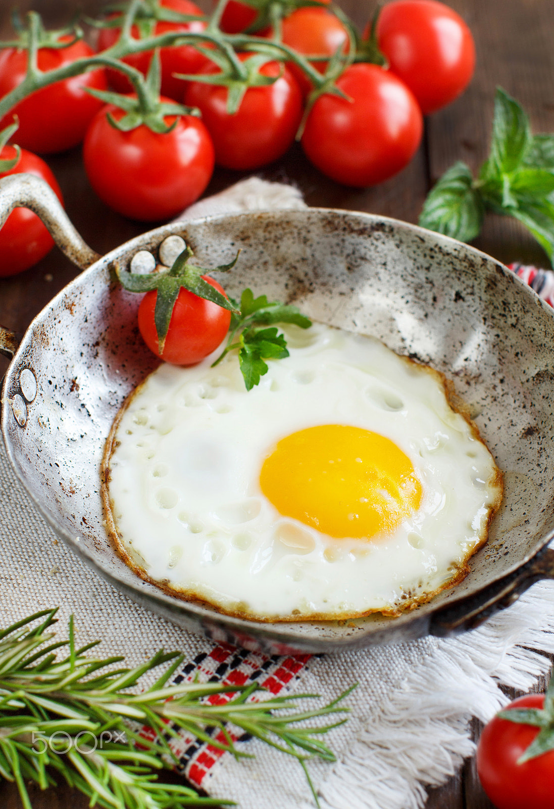 Canon EOS 650D (EOS Rebel T4i / EOS Kiss X6i) + Canon EF 50mm F1.2L USM sample photo. Fried egg with tomatoes and herbs n a old frying pan photography