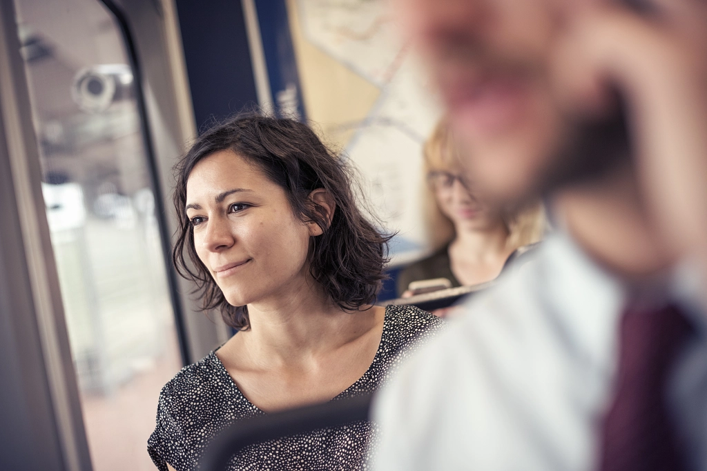 A woman on a busy bus looking out of the window by Mint Images on 500px.com