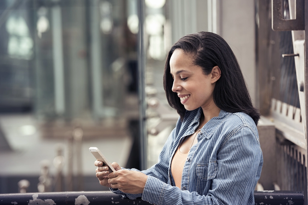 A young woman checking her cell phone by Mint Images on 500px.com