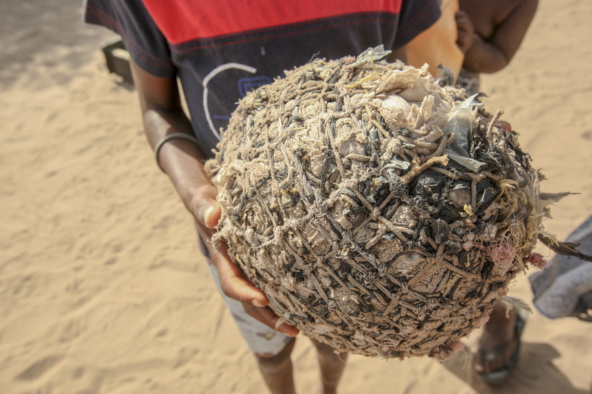 Canon EOS-1D Mark III sample photo. A boy hold a makeshift soccer ball photography