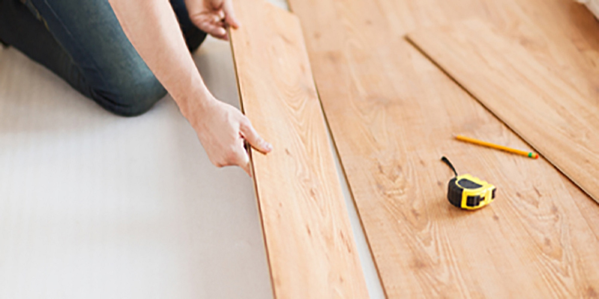 close up of male hands intalling wood flooring