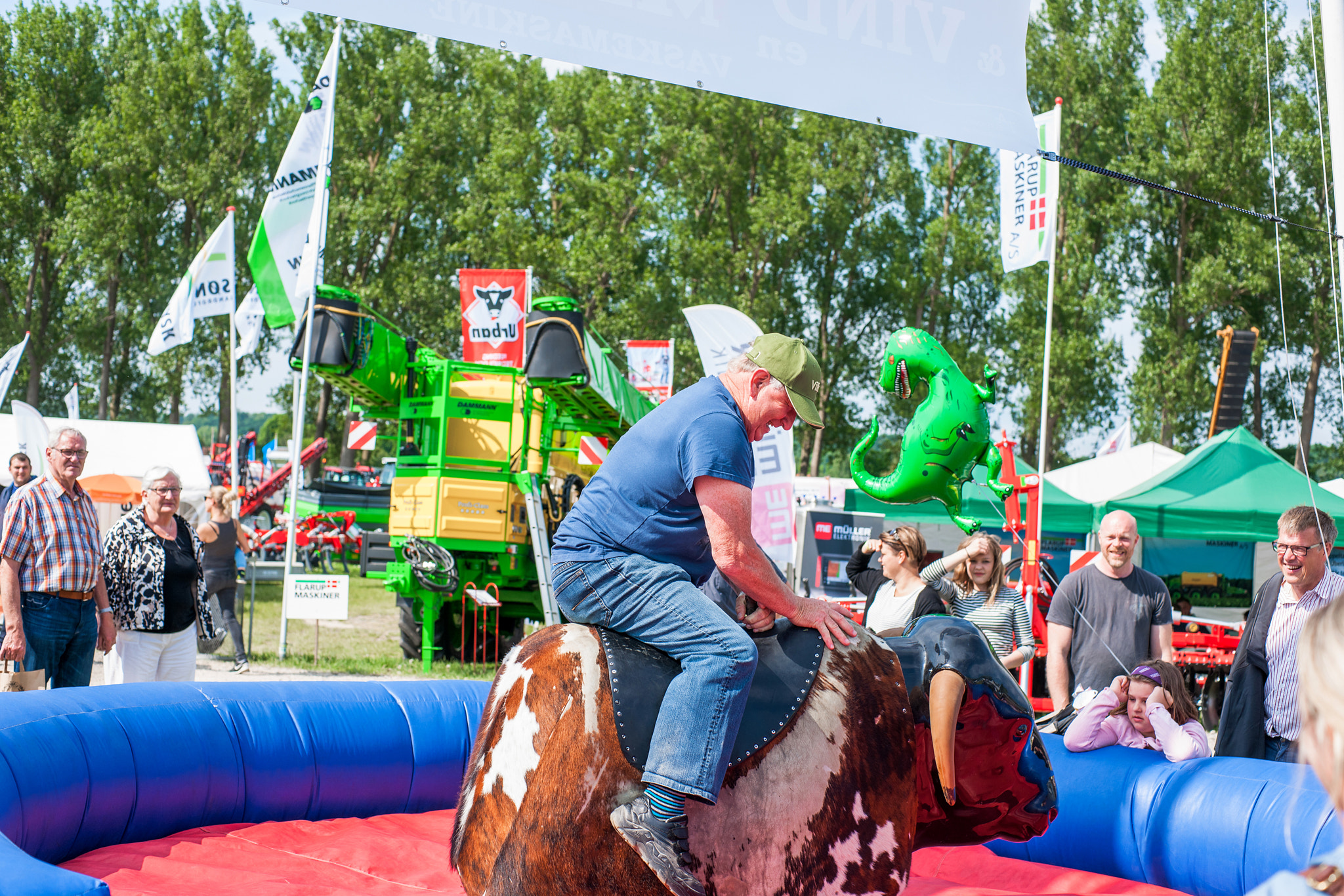 Sony Alpha DSLR-A900 + Sony 50mm F1.4 sample photo. Farmer riding a mechanic bull at a agricultural festival photography