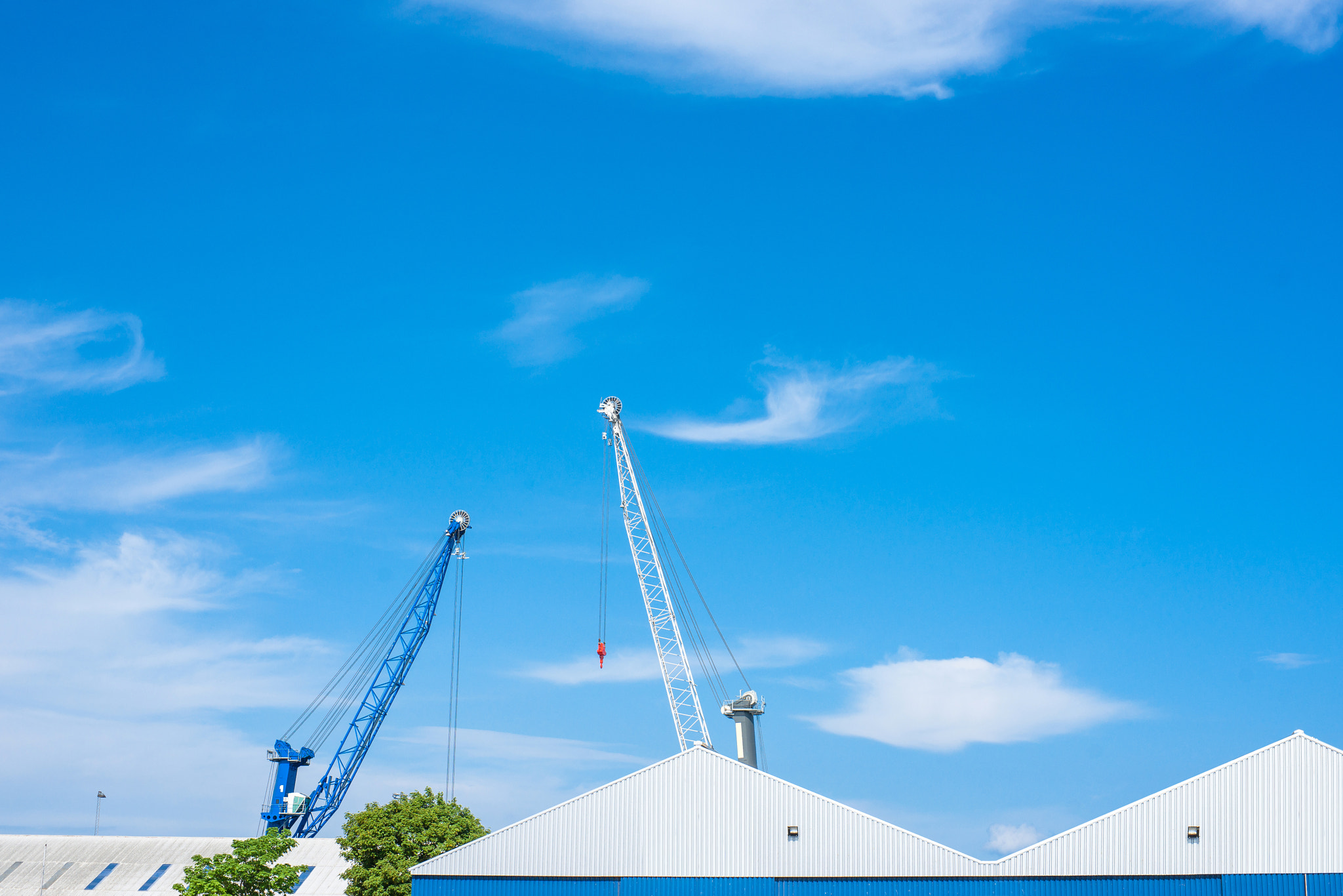 Sony Alpha DSLR-A900 + Sony 50mm F1.4 sample photo. Blue and white cranes at a storage building photography