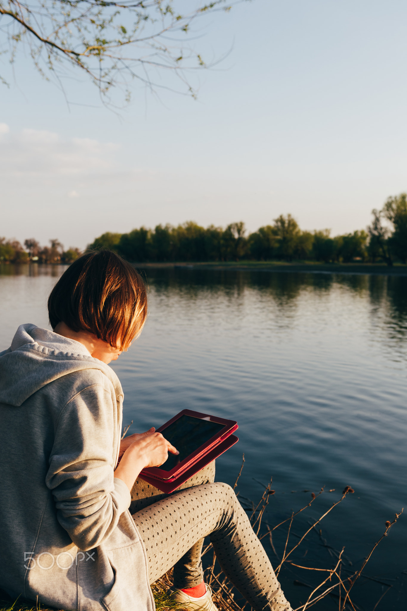 girl working with tablet at the river