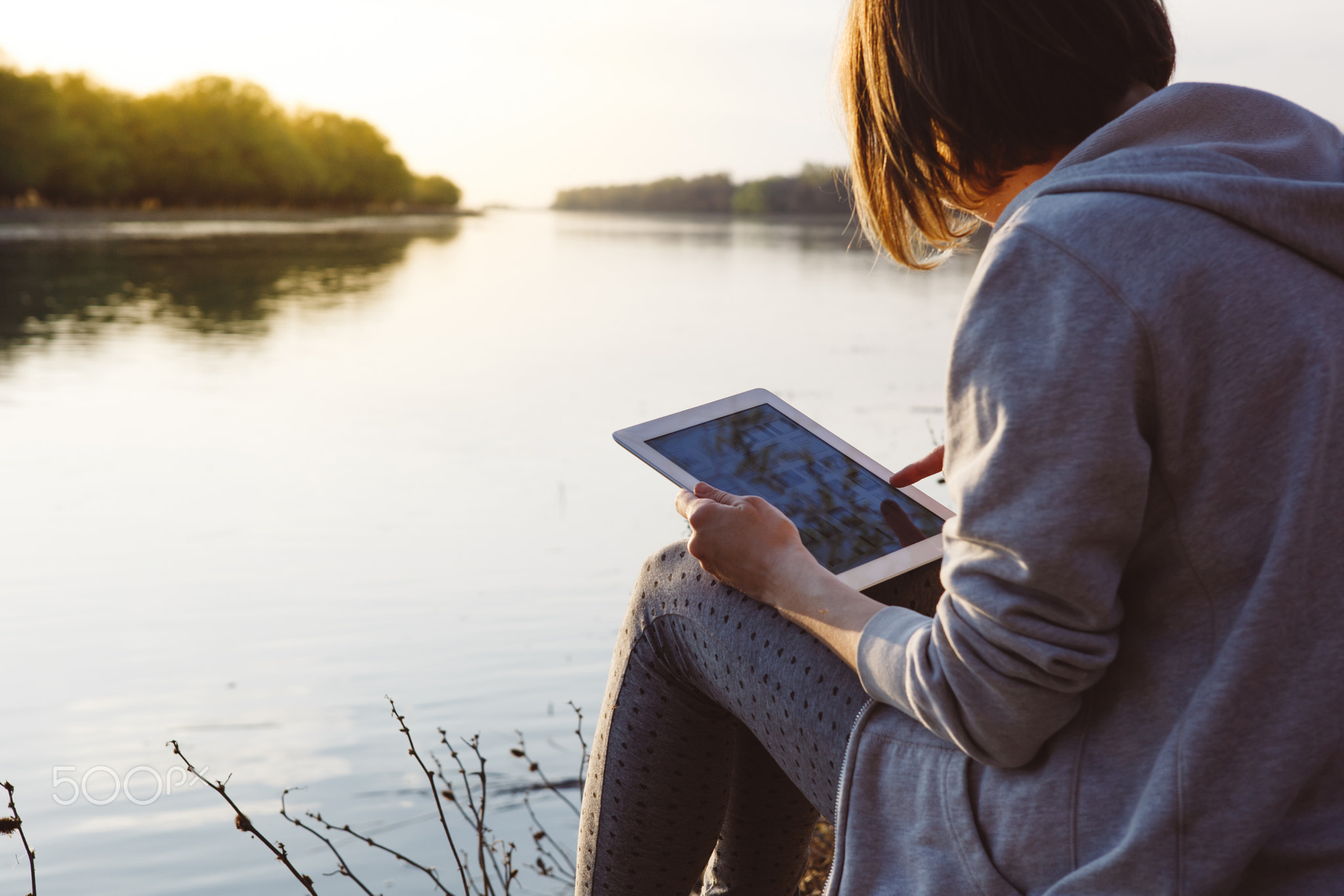 girl working with tablet at the river