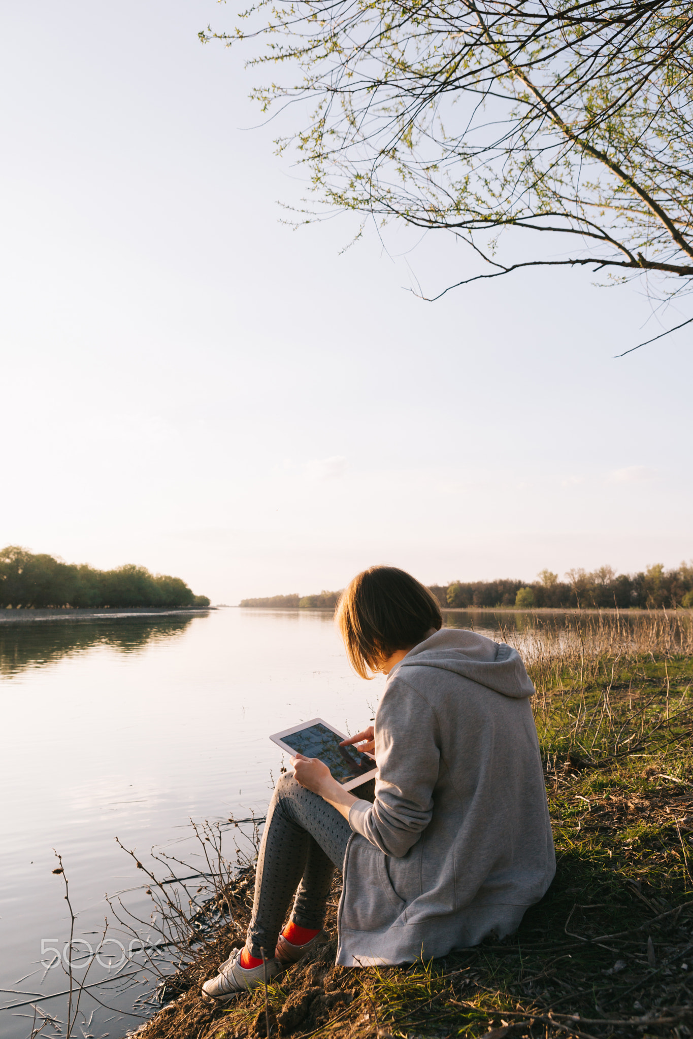 girl working with tablet at the river