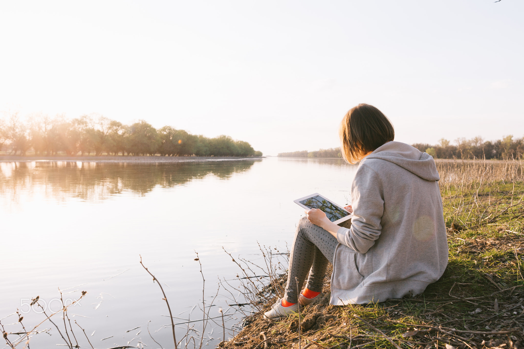 girl working with tablet at the river