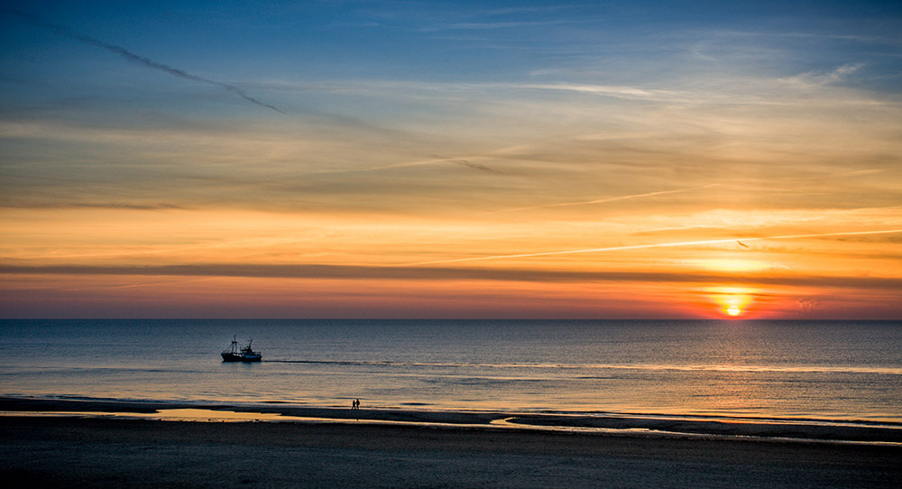 Canon EOS-1D Mark II sample photo. Fishing boat, people and a sunset photography
