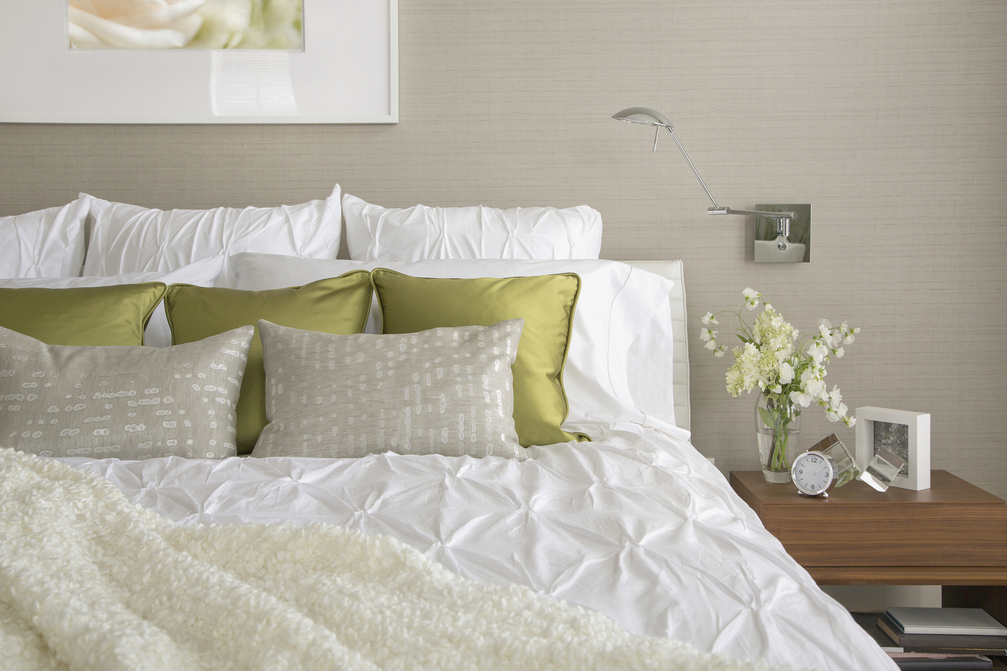 Contemporary bedroom with textured bedding and throw pillows.