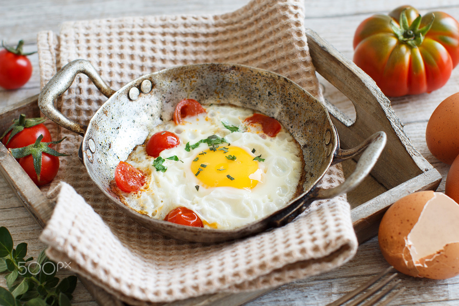 Canon EOS 650D (EOS Rebel T4i / EOS Kiss X6i) + Canon EF 50mm F1.2L USM sample photo. Fried egg with tomatoes and herbs n a old frying pan photography