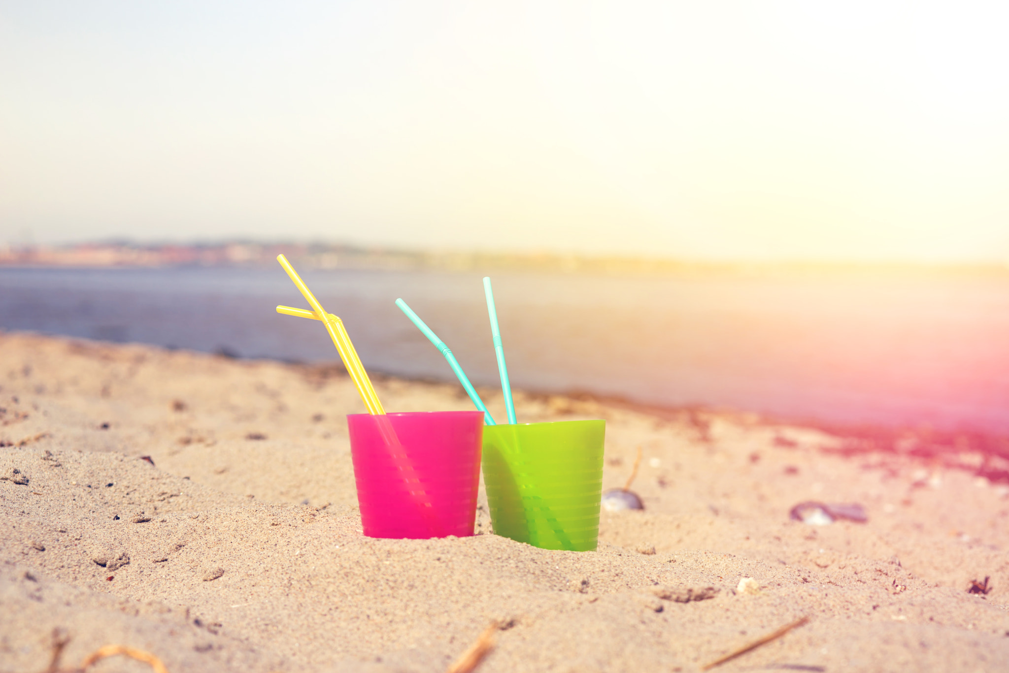 Sony a7R + Sony 50mm F1.4 sample photo. Colorful drink cups in the sand photography