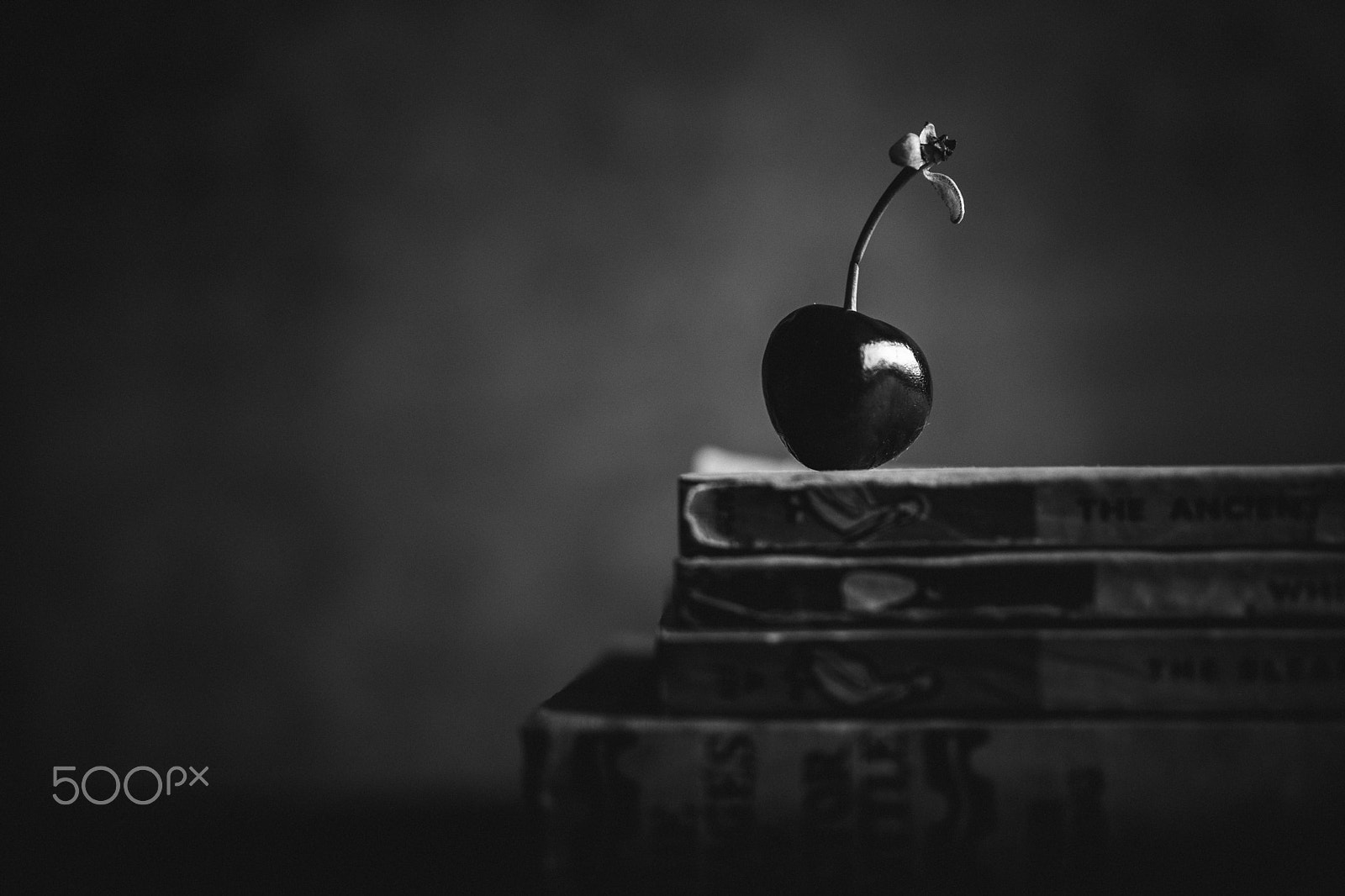 Sigma 30mm F1.4 EX DC HSM sample photo. Single cherry on a pile of vintage books photography