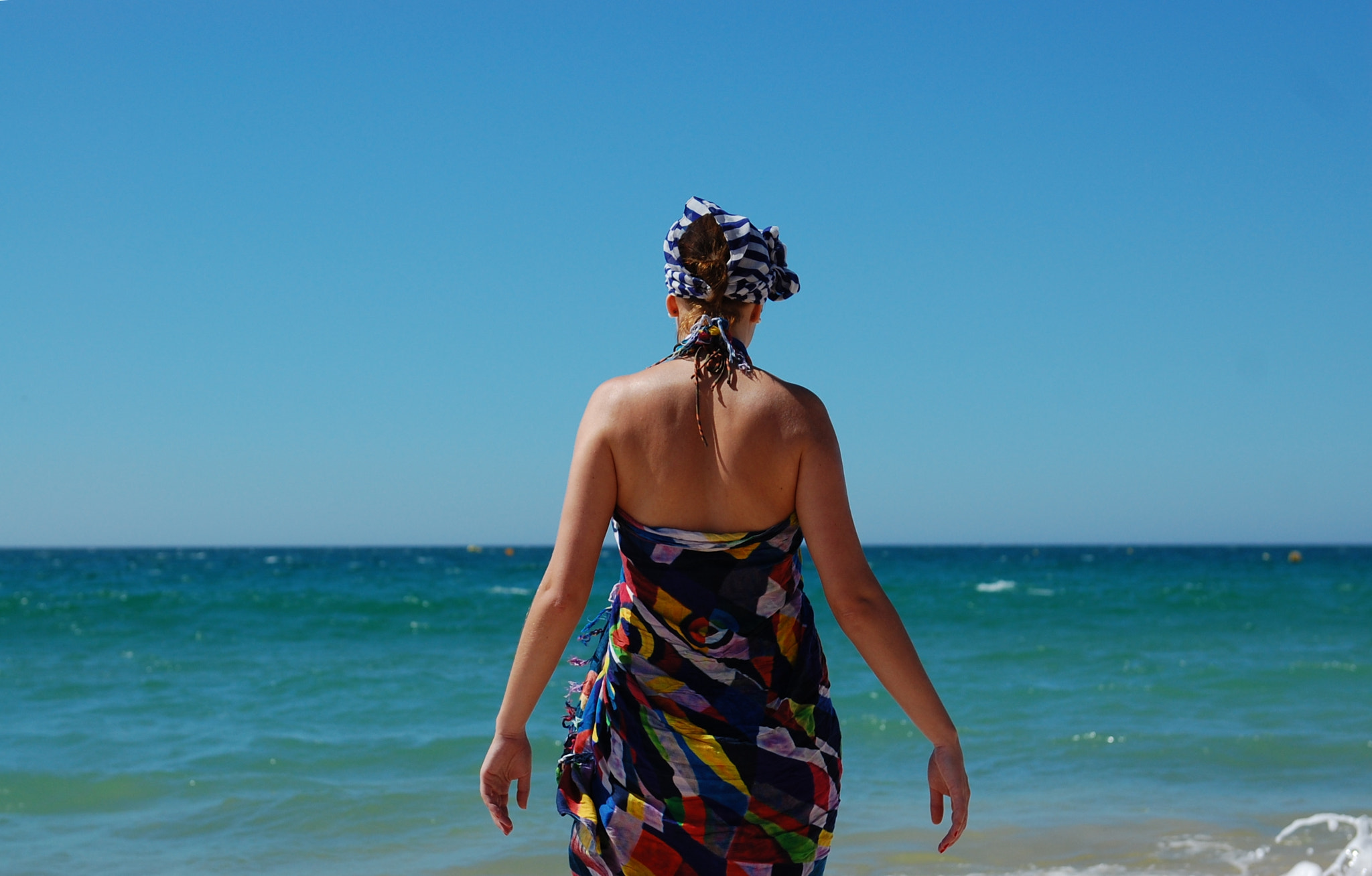 Nikon D40 sample photo. A young woman wearing a hat is walking in beach photography