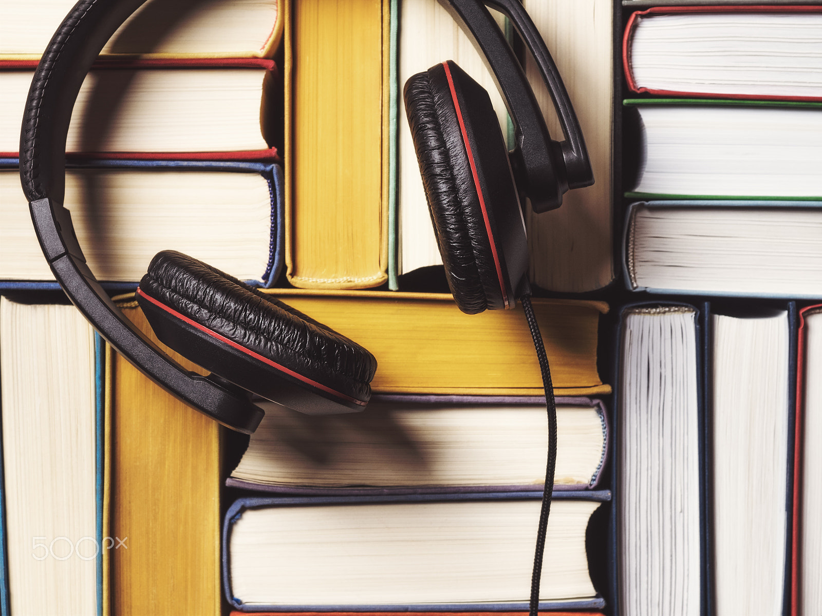 Olympus OM-D E-M1 + OLYMPUS 14-54mm Lens sample photo. Pile of books with headphones photography