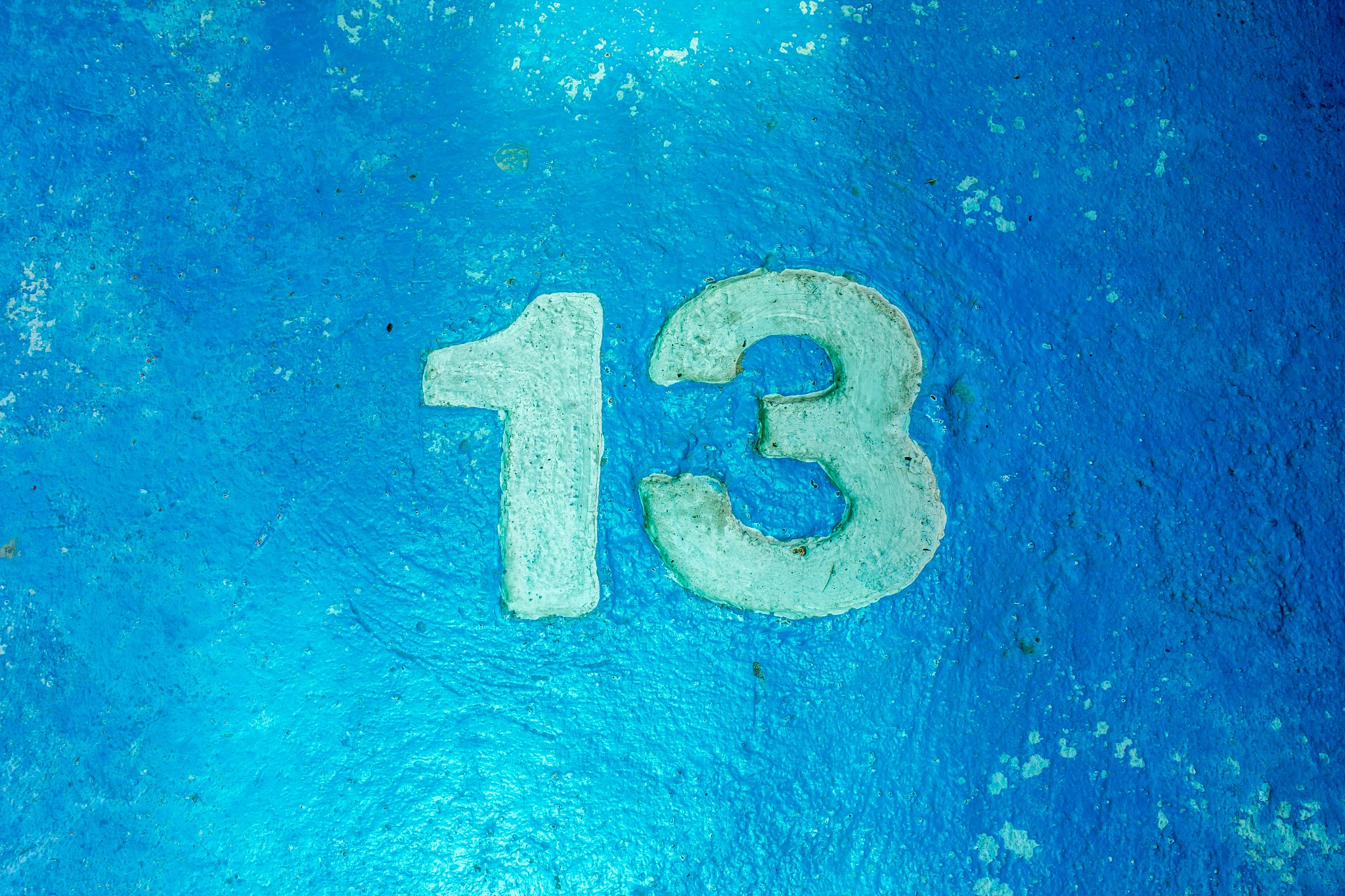 number 13 on blue cement floor