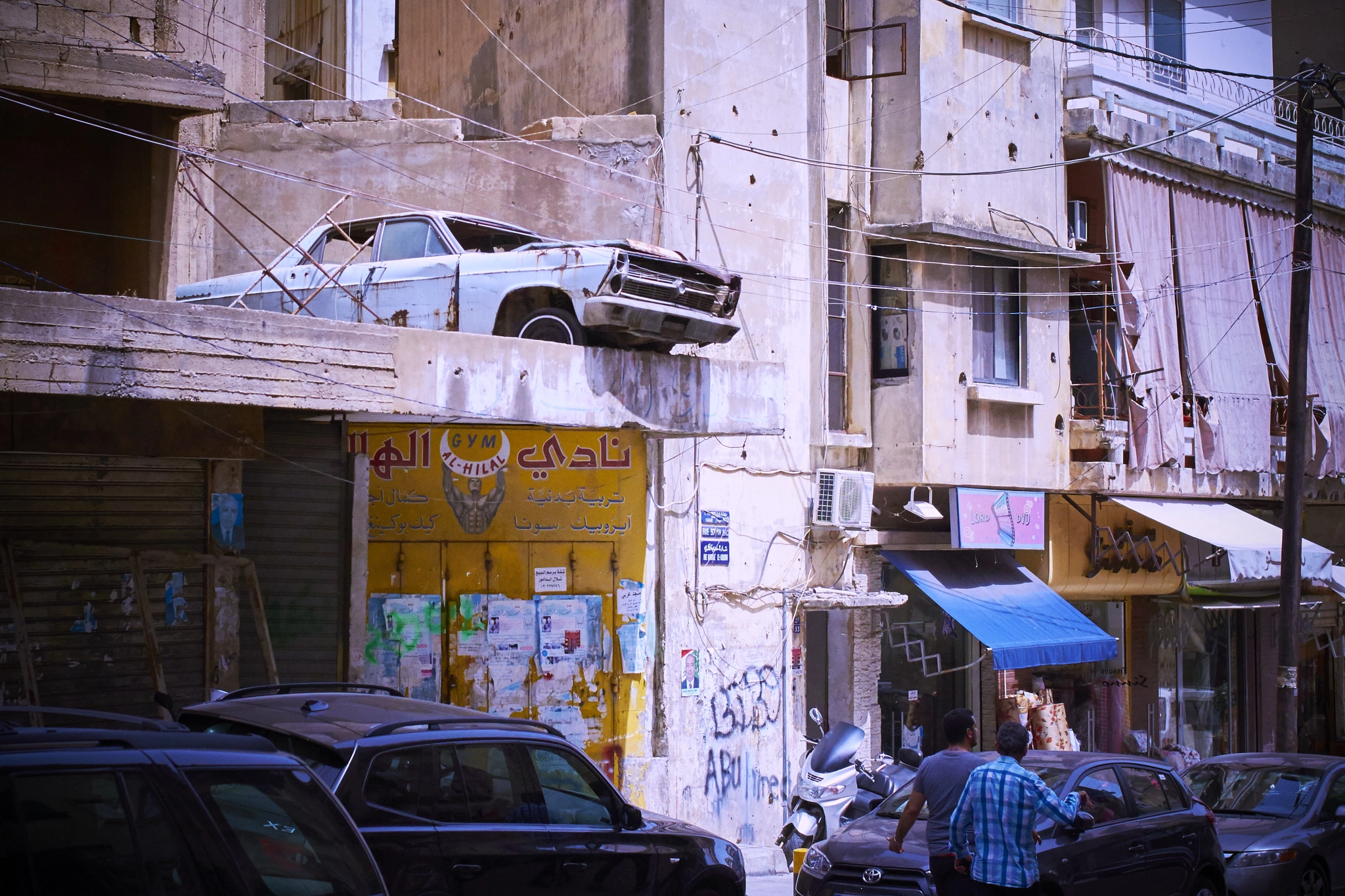 Canon EOS 7D + Canon EF 35mm F2 sample photo. Car hanging in the hezbollah zone of beirut photography