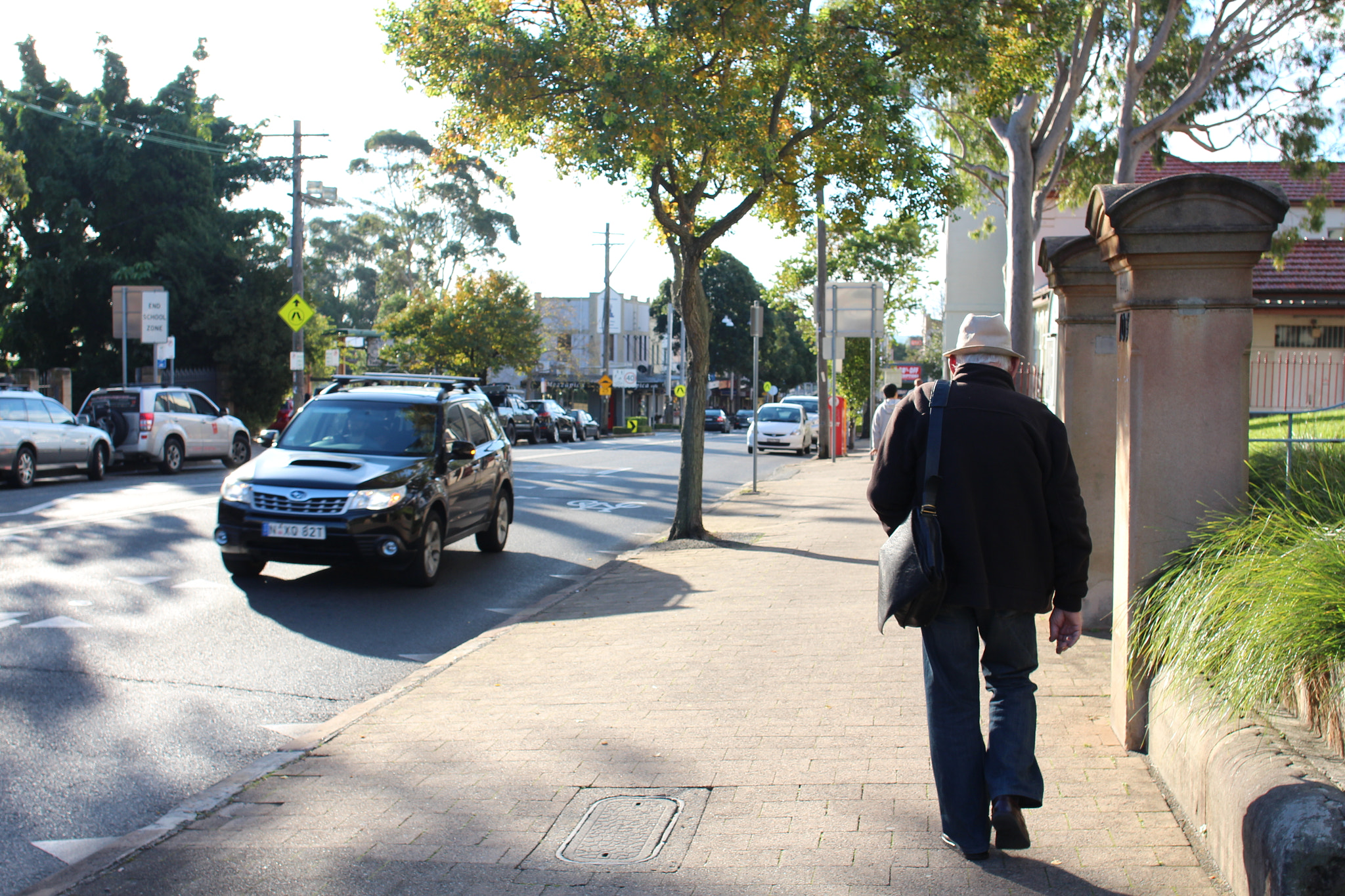 Canon EF 24mm F2.8 IS USM sample photo. Man walking with hat photography