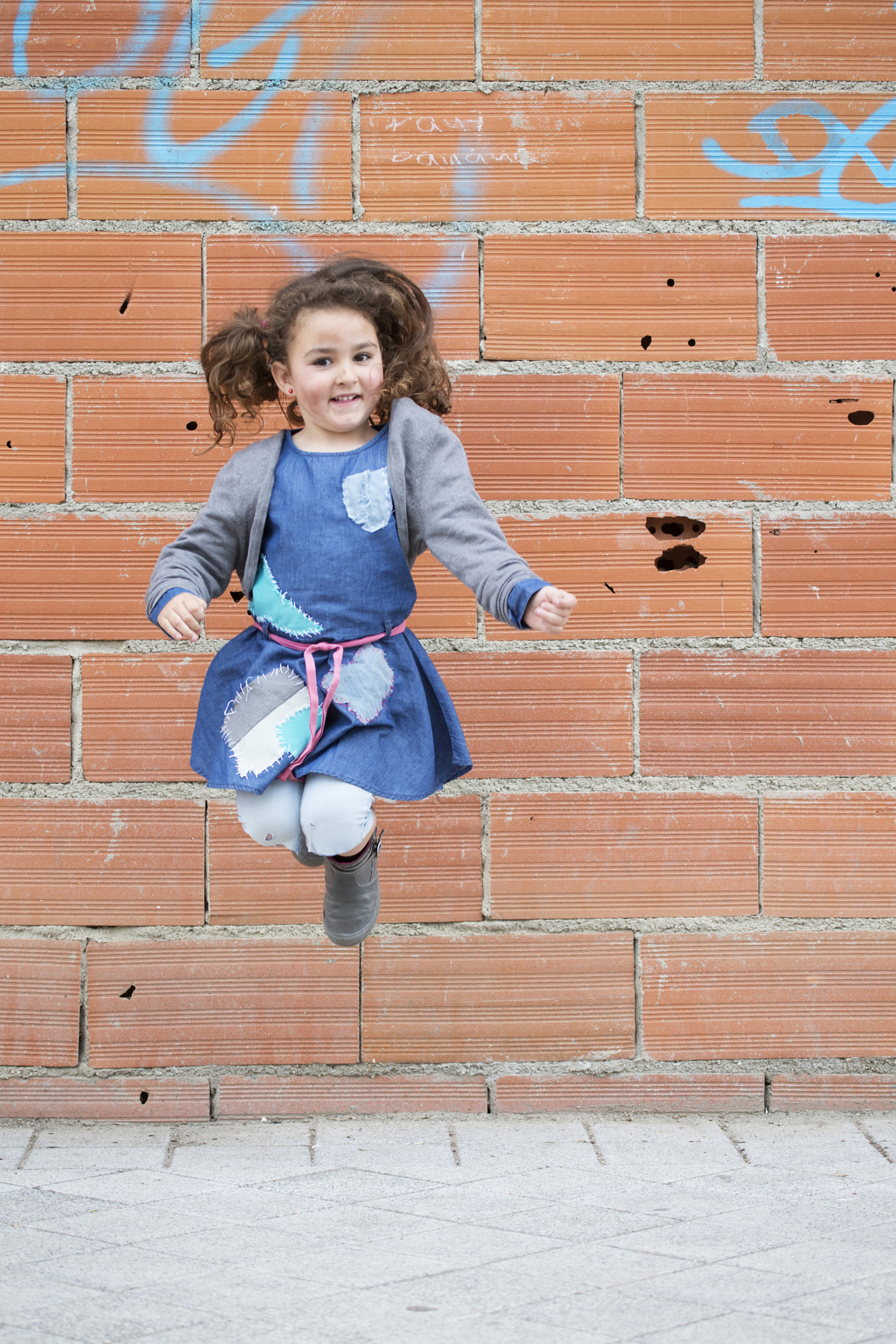 Canon EF 100-400mm F4.5-5.6L IS USM sample photo. Cheerful girl jumping against of brick wall photography