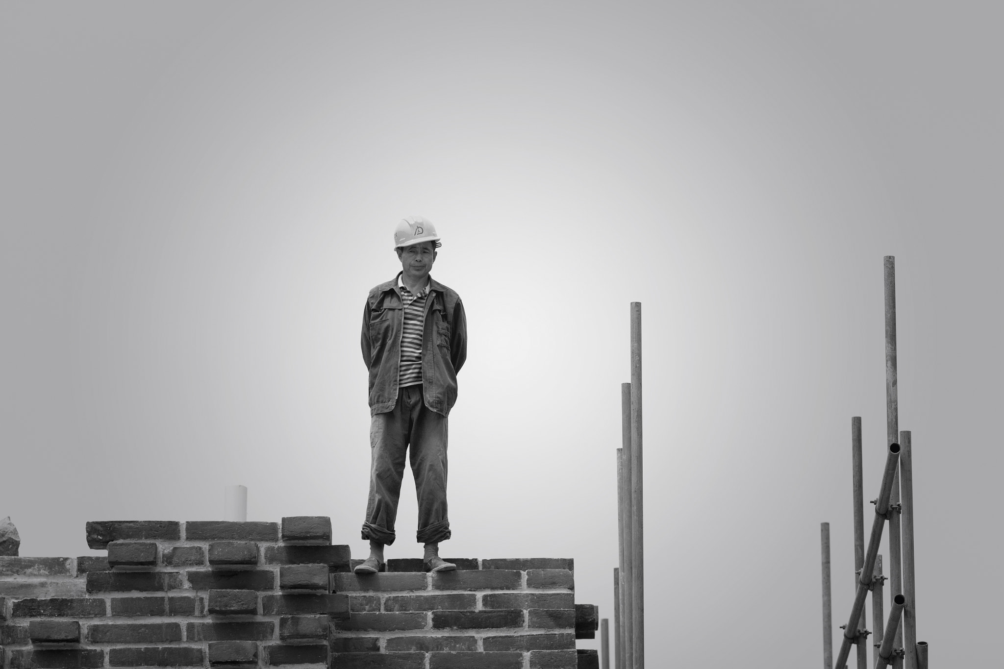 Canon EOS 700D (EOS Rebel T5i / EOS Kiss X7i) + Canon EF 135mm F2L USM sample photo. A worker on the roof photography