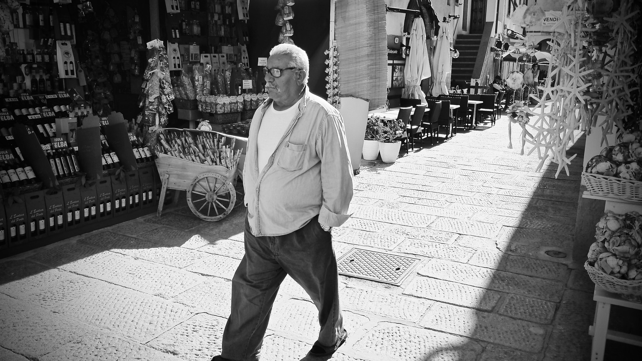 Olympus OM-D E-M10 + Panasonic Lumix G 14mm F2.5 ASPH sample photo. Old man in a very nice city photography