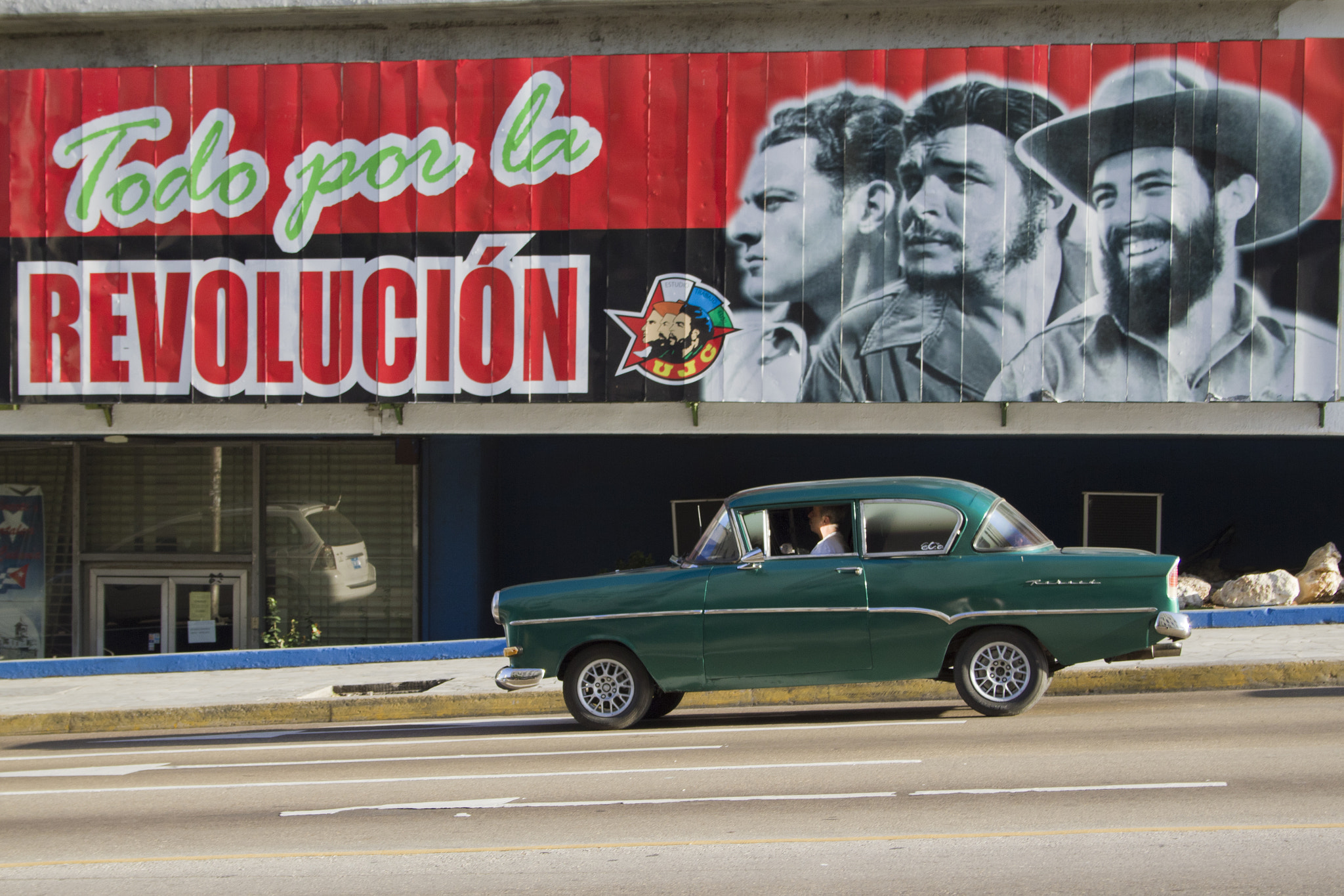 Canon EOS 7D + Canon EF-S 18-55mm F3.5-5.6 sample photo. Classic car driving by sign, cuba photography