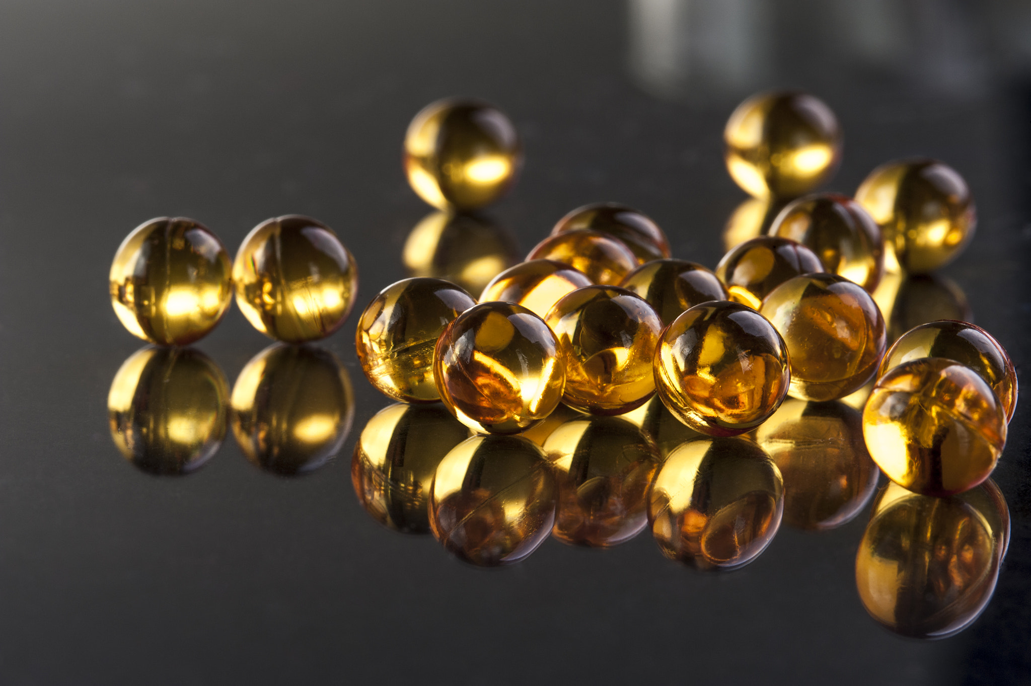 Nikon D700 + AF Micro-Nikkor 105mm f/2.8 sample photo. Omega capsules on black background photography