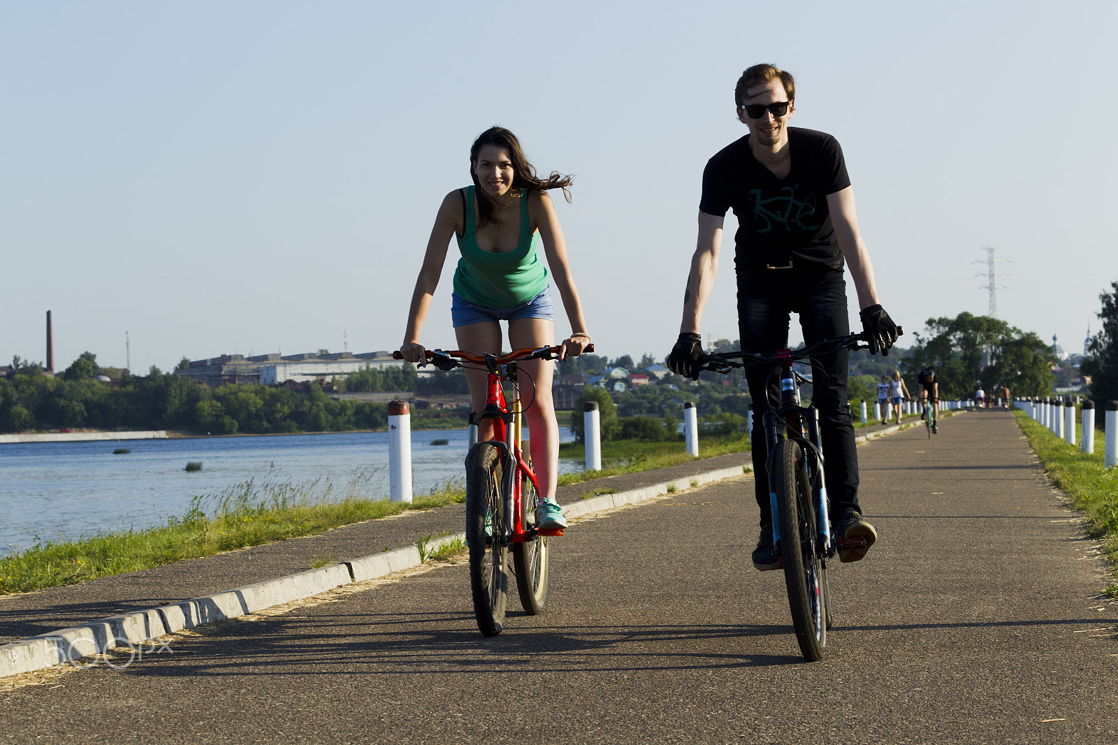 Canon EOS-1D Mark IV sample photo. The girl and the young man ride on a bicycle in the city photography