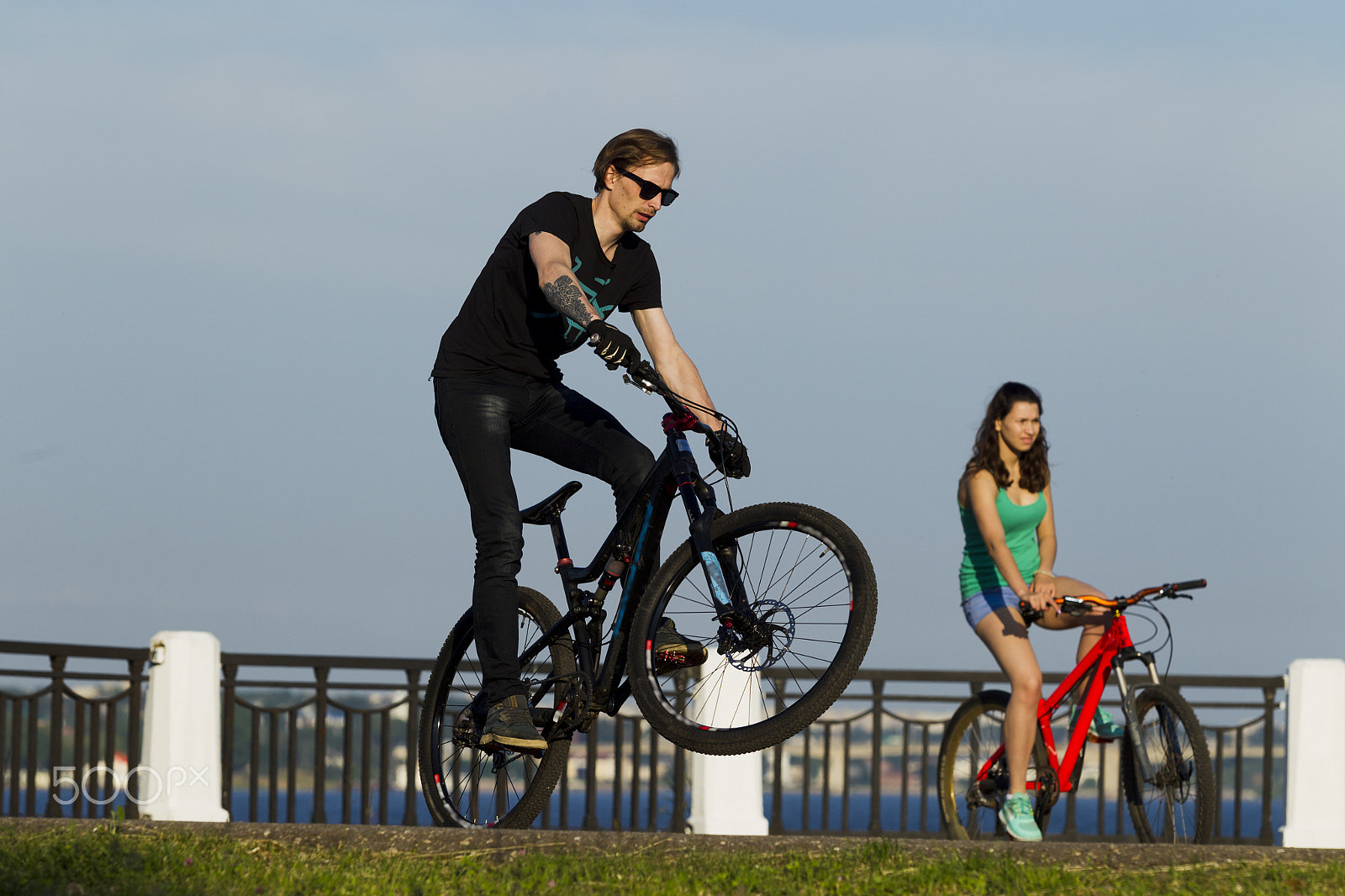 Canon EOS-1D Mark IV sample photo. The girl and the young man ride on a bicycle in the city photography