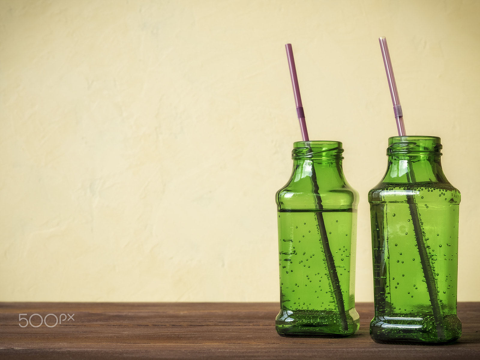 Olympus OM-D E-M1 + OLYMPUS 14-54mm Lens sample photo. Green bottles on wooden table photography
